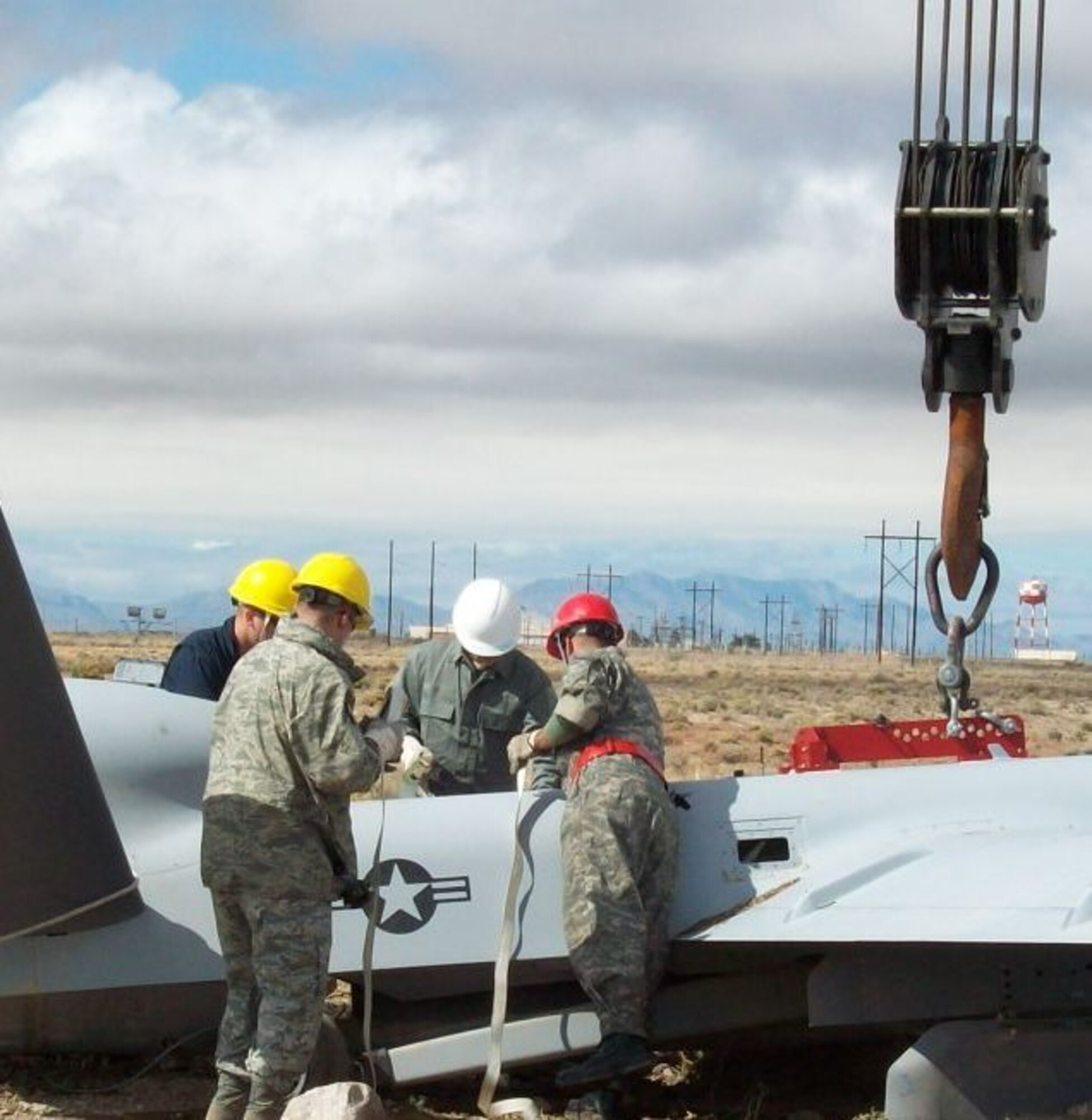 HOLLOMAN AIR FORCE BASE, N.M. -- Members of the 49th Aircraft Maintenance Squadron Crash Recovery and Program Maintenance Package section look over an MQ-9 Reaper in Oct. 2010, after it crashed by the flight line. The 49th AMXS Crash Recovery and PMP team is the only organization of its kind on the base and is responsible for safely recovering any locally assigned or transient aircraft that crash. (Courtesy Photo)