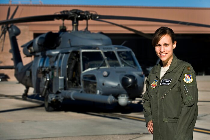 Maj. Jennifer Aupke, 88th Test and Evaluation Squadron helicopter pilot, poses with an HH-60G Pavehawk Jan. 6, 2012, at Nellis Air Force Base, Nev.  During her free time, Aupke volunteers with "Books and Buddies," a program that is dedicated to helping elementary-age children with reading through weekly one-on-one help sessions.  (U.S. Air Force photo by Senior Airman Brett Clashman/Released)