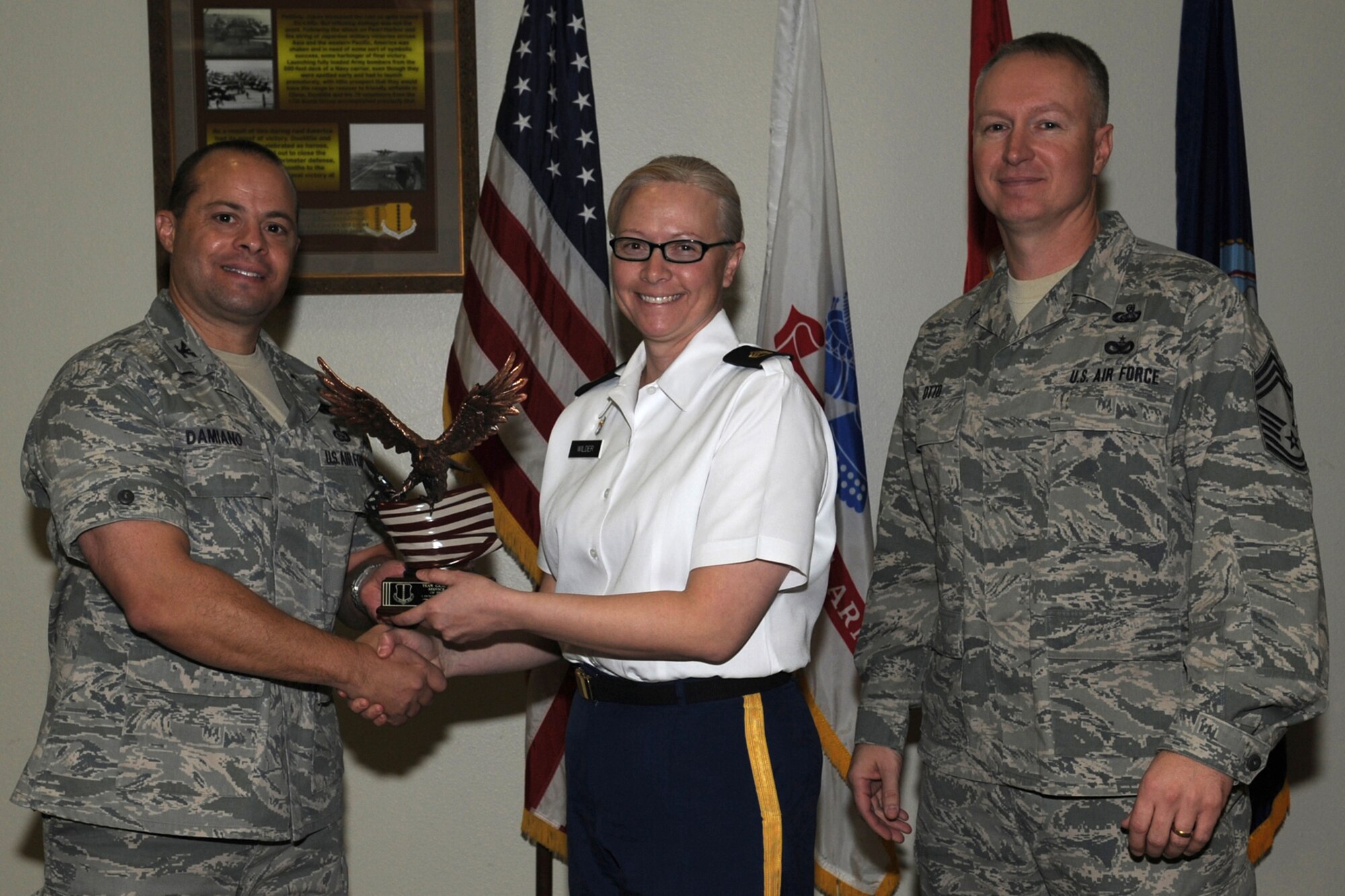 GOODFELLOW AIR FORCE BASE, Texas -- Col. Mark Damiano, 17th Training Wing Commander, and Chief Master Sgt. Quinton Otto, 17th Mission Support Group Superintendent, present the Team Goodfellow NCO of the Quarter to Army Staff Sgt. Tahni Wilder, 344th Military Intelligence Battalion, during the wing quarterly awards ceremony Jan. 5. (U.S. Air Force photo/Staff Sgt. Laura R. McFarlane)