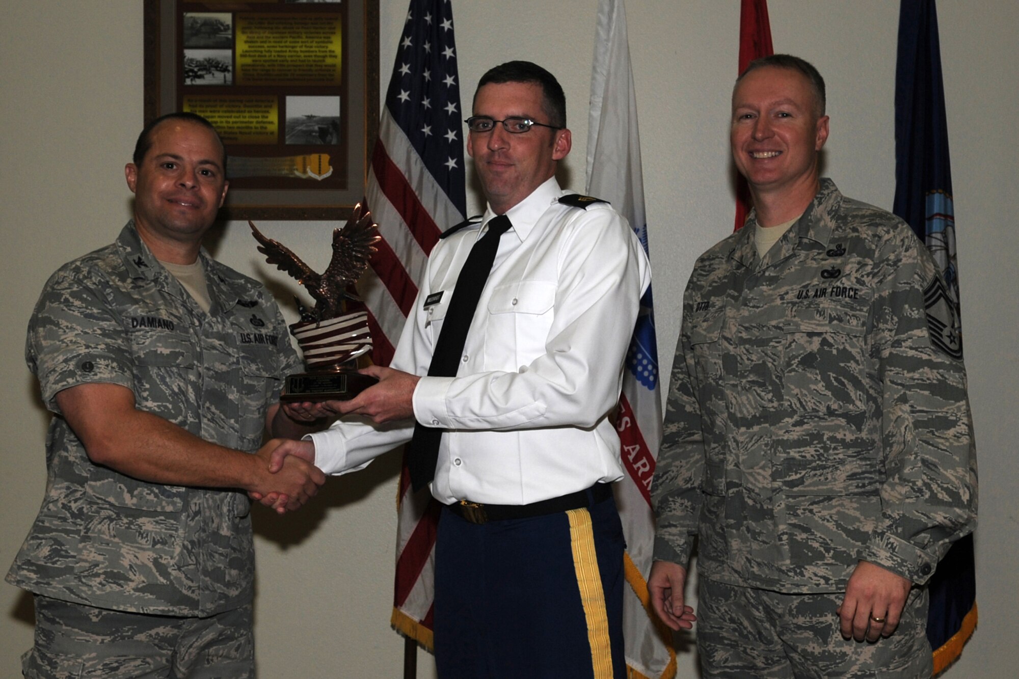 GOODFELLOW AIR FORCE BASE, Texas -- Col. Mark Damiano, 17th Training Wing Commander, and Chief Master Sgt. Quinton Otto, 17th Mission Support Group Superintendent, present the Team Gooodfellow Volunteer of the Quarter award to Army Staff Sgt. Timothy Masshardt, 344th Military Intelligence Battalion, during the wing quarterly awards ceremony Jan. 5. (U.S. Air Force photo/Staff Sgt. Laura R. McFarlane)