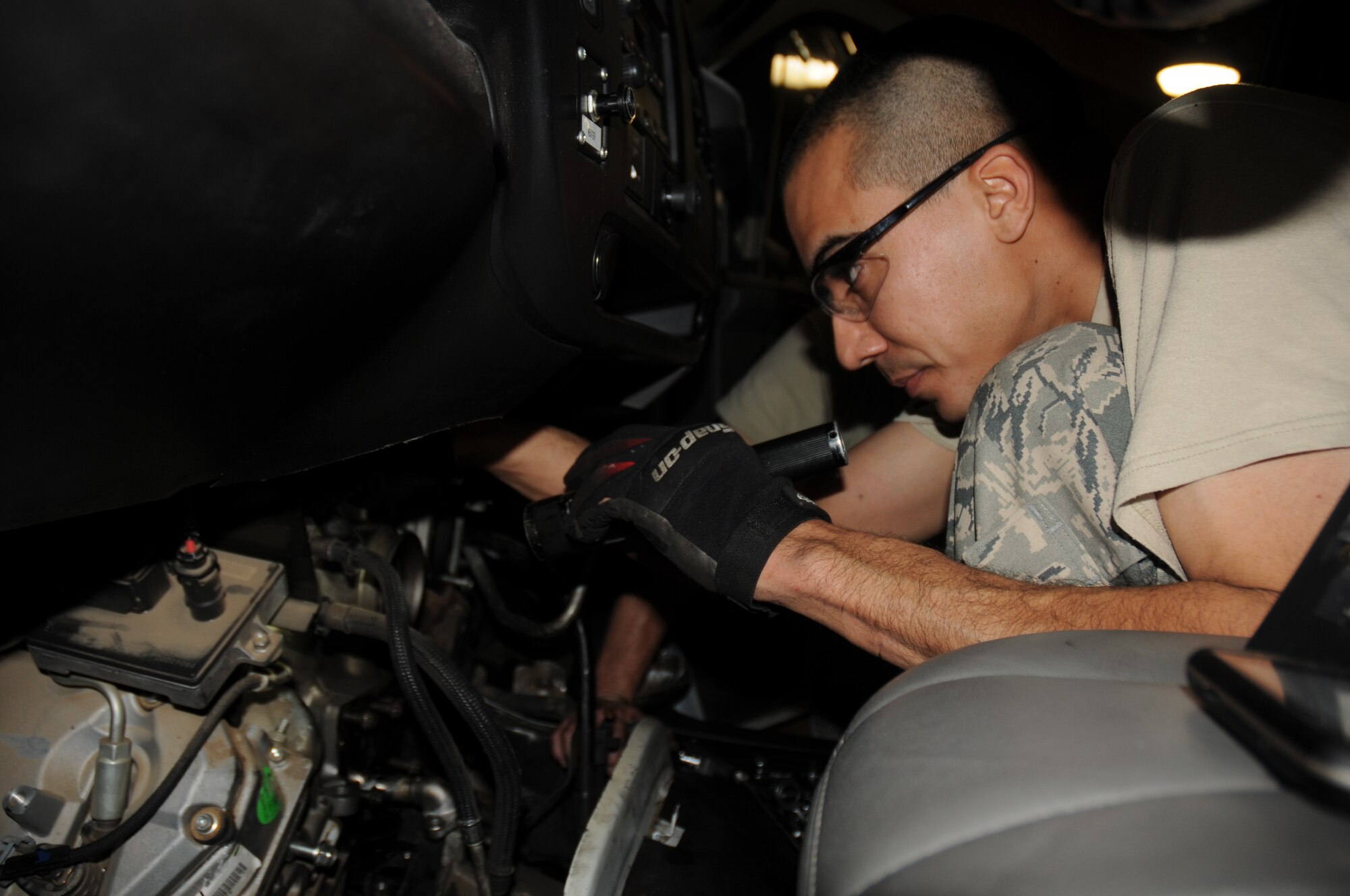 Tech. Sgt. Michael A. Salmon, 944th Logistics Readiness Squadron, vehicle maintenance technician, uses a flashlight while trying to remove a malfunctioning turbo assembly from a 2007 Chevrolet government van or “bread van,” Jan. 7 during his unit training assembly at the 56th Vehicle Maintenance Shop, Luke Air Force Base, Ariz.  “We have a reservist who works with the 56th as a civilian who sets aside good training jobs and simple tasks that can be completed on the weekend between our other training requirements,” said Tech. Sgt. Gabriel E. Klemm, 944th Logistics Readiness Squadron, multipurpose vehicle maintenance craftsman. “Routinely the 56th will have jobs that take longer than a day to complete.  If that job was started prior to close of business Friday and the job can be completed over the weekend, we partner to finish it.”  (U.S. Air Force photo/Staff Sgt. Louis Vega Jr.)