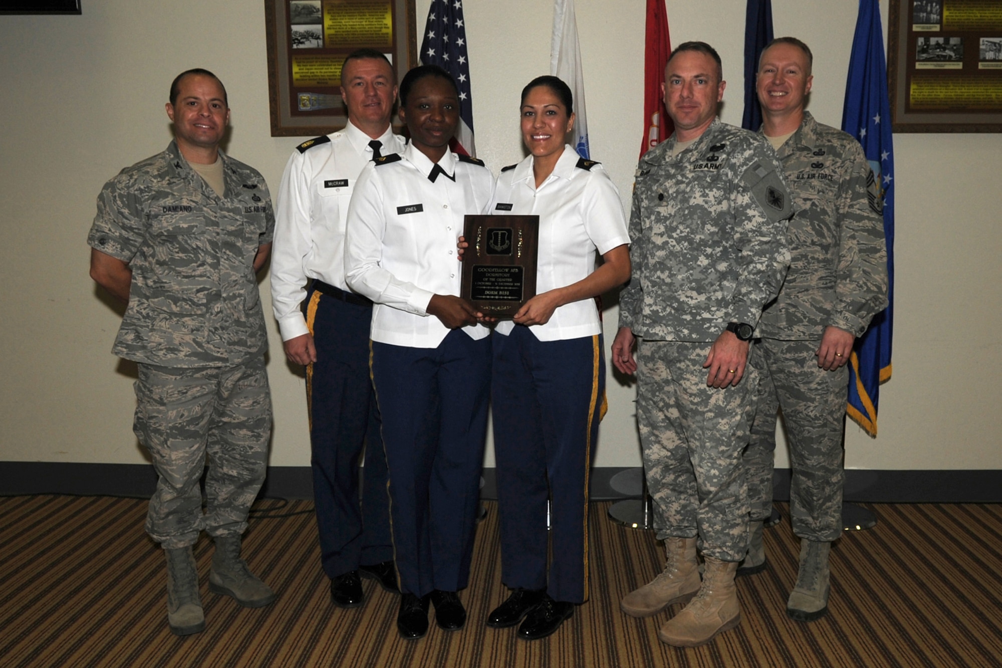 GOODFELLOW AIR FORCE BASE, Texas -- Col. Mark Damiano (left), 17th Training Wing Commander, and Chief Master Sgt. Quinton Otto (right), 17th Mission Support Group Superintendent, present the 344th Military Intelligence Battalion with the Team Gooodfellow, Goodfellow Air Force Base Dormitory of the Quarter for Dorm 252 during the wing quarterly awards ceremony Jan. 5. The 311th Training Squadron Dorm 627 won the Team Goodfellow Presidio of Monterey Dormitory of the Quarter. (U.S. Air Force photo/Staff Sgt. Laura R. McFarlane)