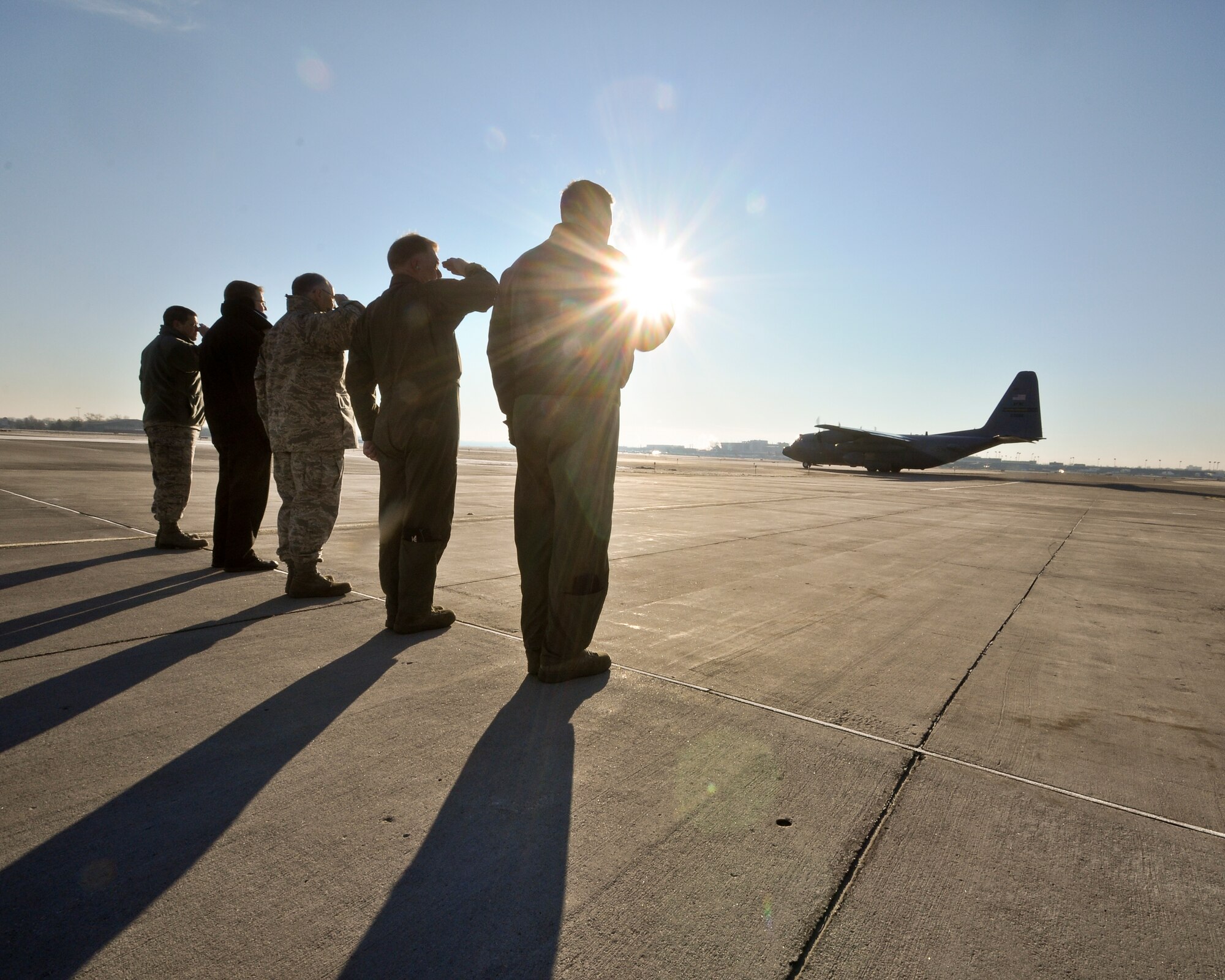 934th Airlift Wing leaders salute the deploying Airmen as their aircraft taxis for takeoff.  (Air Force Photo/Tech Sgt. Bob Sommer)
