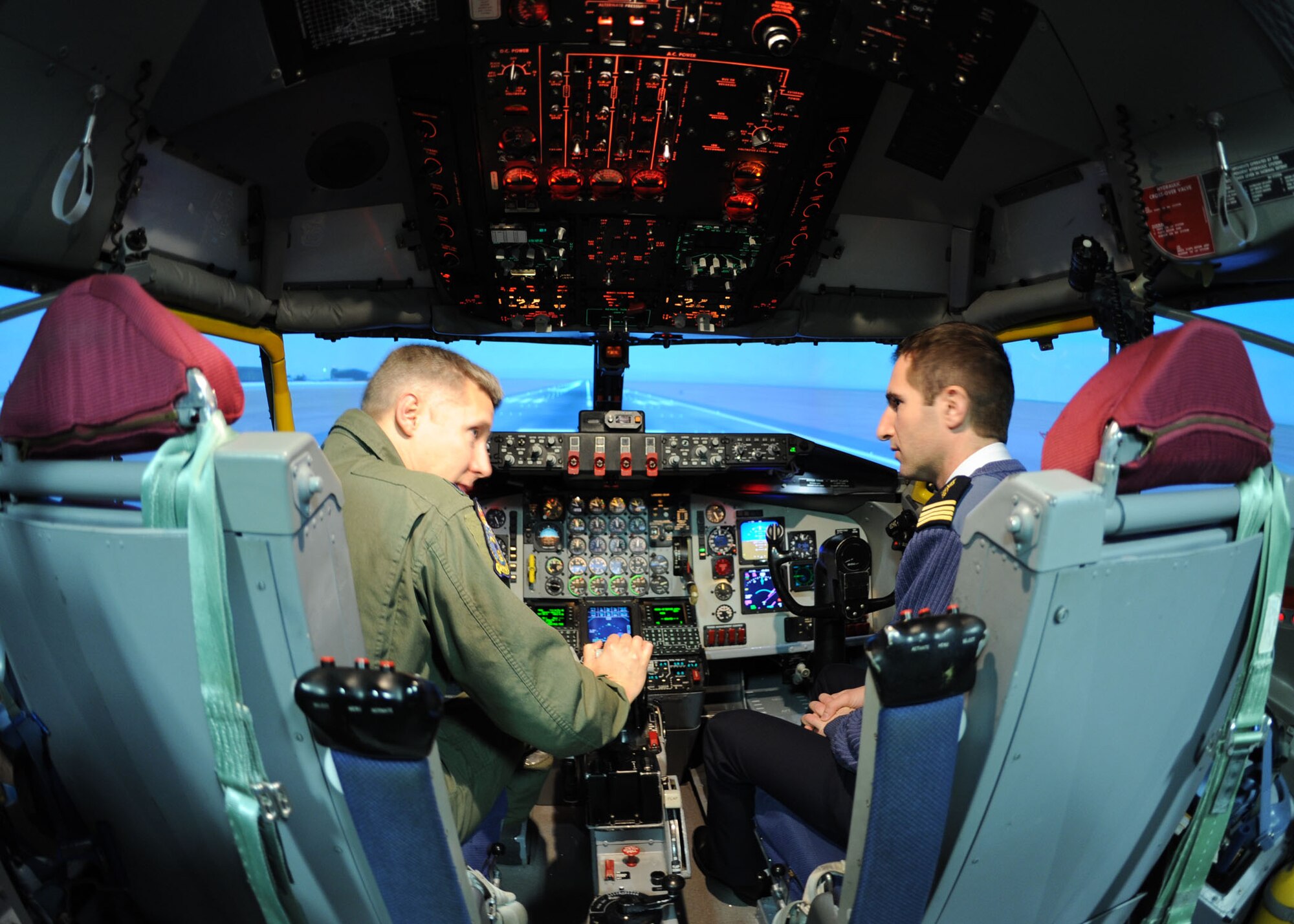 RAF MILDENHALL, England – Lt. Col. Robert Ricks, 100th Air Refueling Wing director of staff, shows French air force Maj. Sebastien Pages the cockpit of a KC-135 Stratotanker aircraft flight simulator here Jan. 5, 2012. A group of French airmen visited the base as part of efforts to maintain and strengthen U.S. and French air force working relationships. (U.S. Air Force photo/Tech. Sgt. Neal X. Joiner)