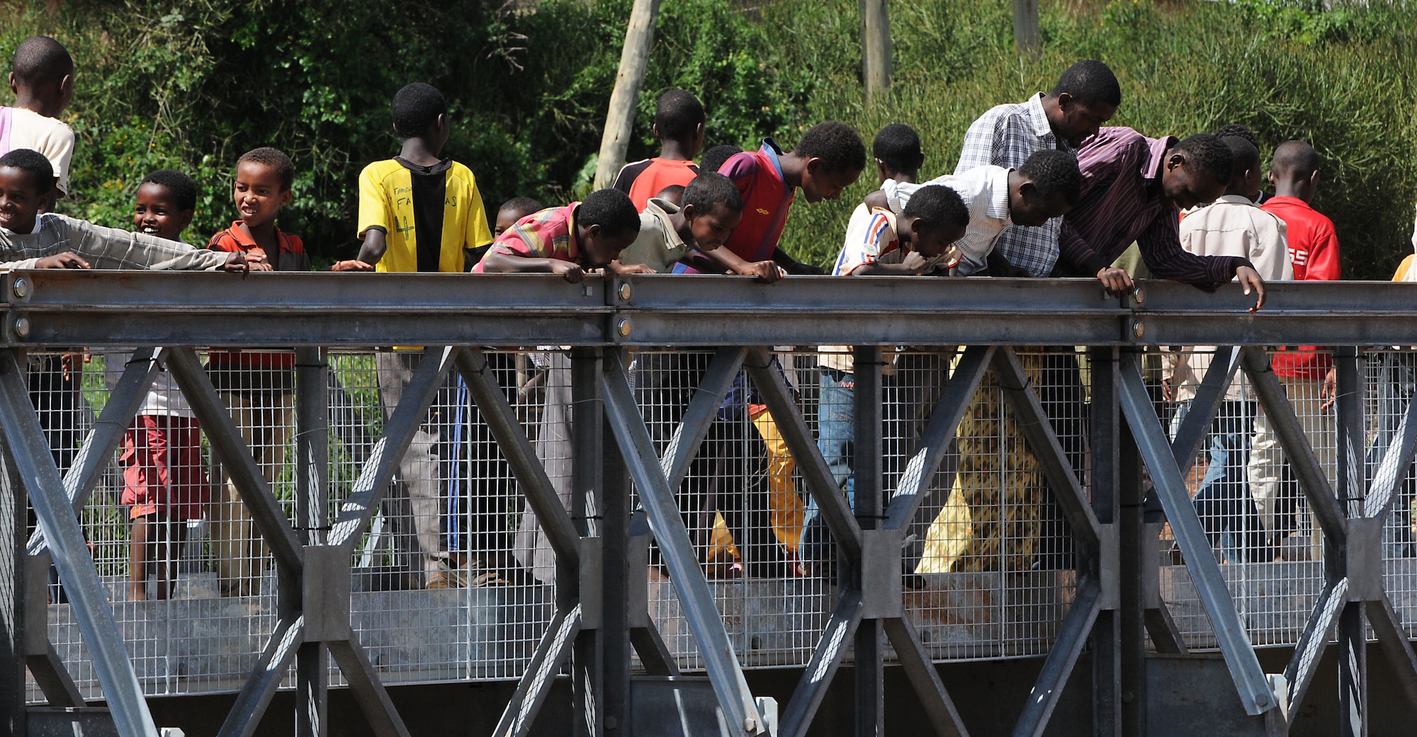 Local residents stare down at the river below from the recently dedicated bridge in Negele Borena, Ethiopia, Dec. 6, 2011. Each year during the rainy season, the river claims the lives of about three people who attempt to ford through the strong currents and deep waters. (U.S. Air Force photo/Senior Airman Jarad Denton)