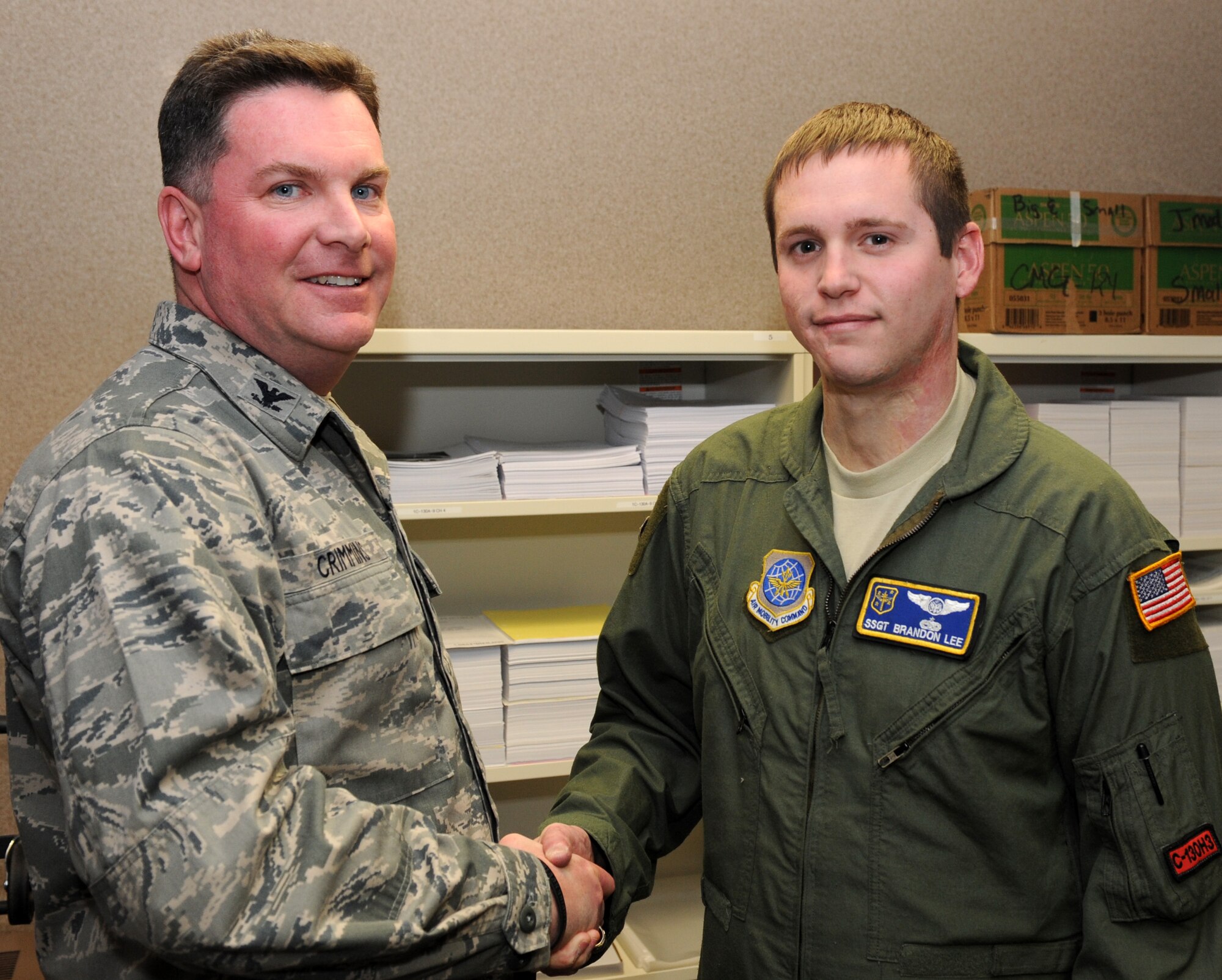 Col. Thomas Crimmins , 19th Airlift Wing vice commander, presents a commander’s coin to Staff Sgt. Brandon Lee, the 19th Operations Group flight engineer, Jan. 3, 2012, at Little Rock Air F orce Base, Ark. Lee, a Blackshear, Ga., native, has issued more than $23,000 worth of flight publications to squadrons around base. (U.S. Air Force photo by Airman 1st Class Rusty Frank)