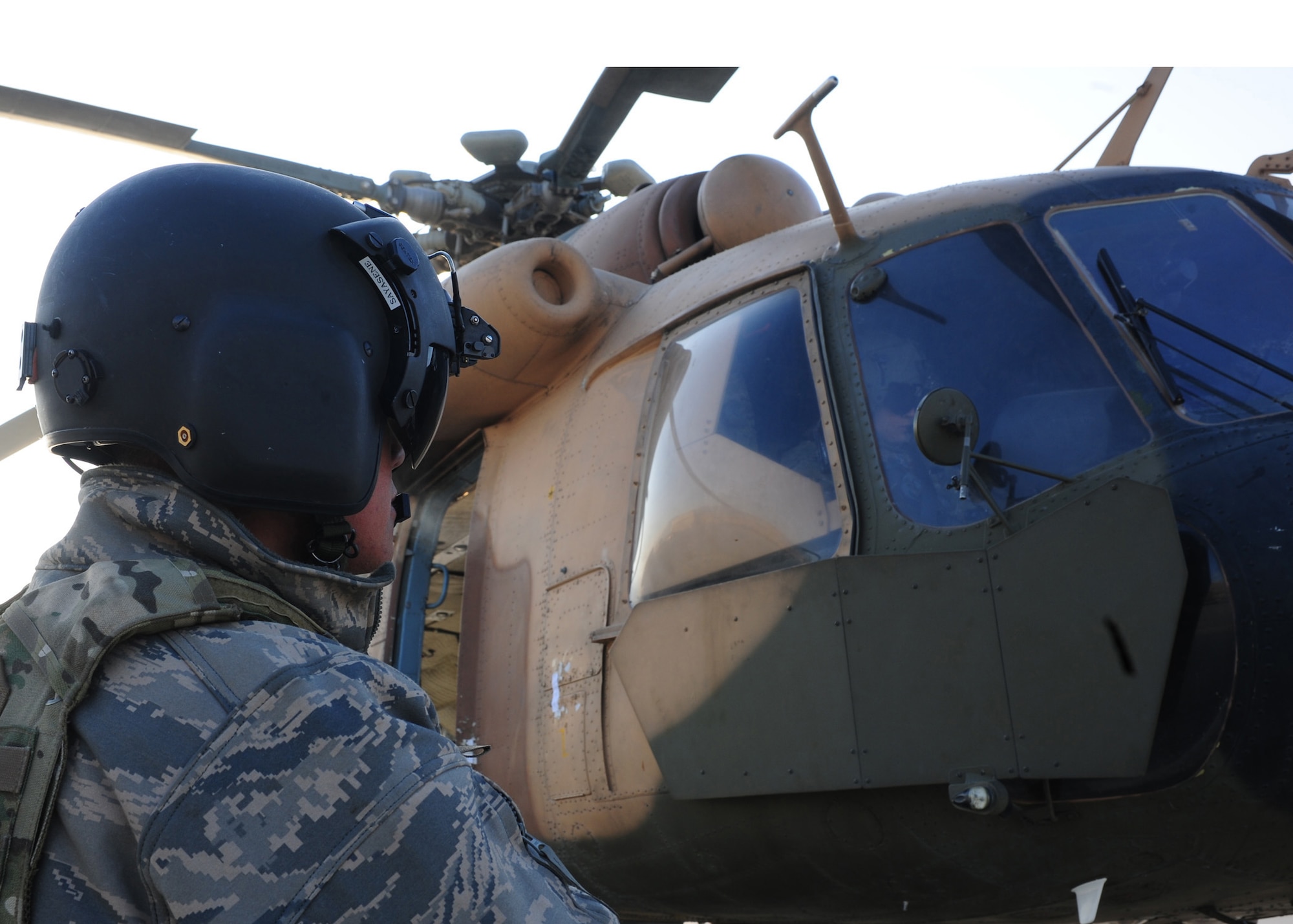 Tech. Sgt. Jerry Sayasene, a flight engineer with the 438th Air Expeditionary Advisory Squadron, performs communication check with the pilot of an Afghan air force MI-17 prior to a supply flight over northern Afghanistan, Dec. 21, 2011, at Kabul International Airport. Sayasene is currently deployed to provide advisory training for Afghan air force flight engineers. (U.S. Air Force photo by Staff Sgt. Nadine Y. Barclay)
