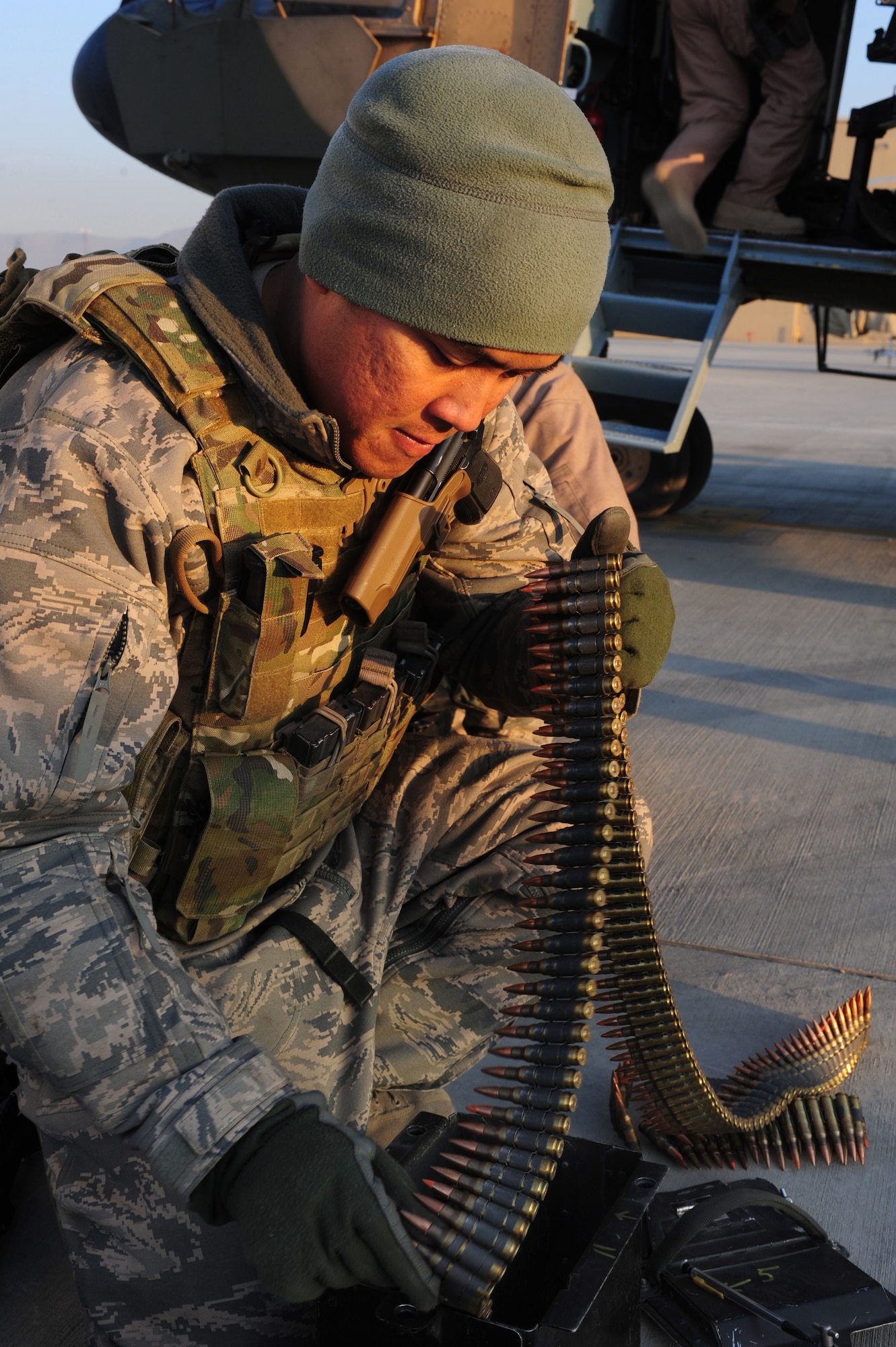 Tech. Sgt. Jerry Sayasene, a flight engineer with the 438th Air Expeditionary Advisory Squadron, loads ammunition for a M240 machine gun prior to a supply flight over northern Afghanistan, Dec. 21, 2011, at Kabul International Airport. Sayasene is currently deployed to provide advisory training for Afghan air force flight engineers. (U.S. Air Force photo by Staff Sgt. Nadine Y. Barclay)