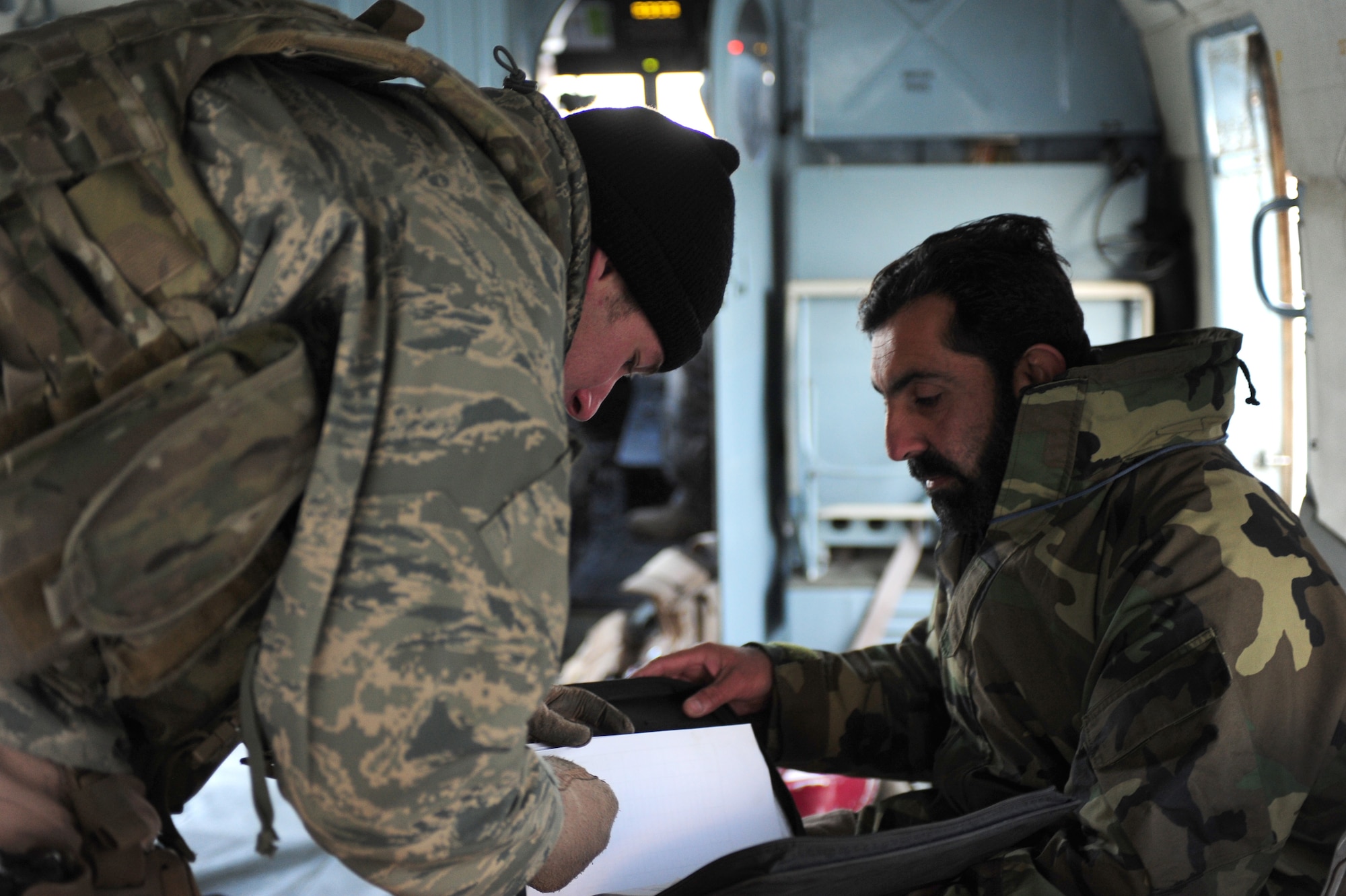 Staff Sgt. Justin Trumpower, a flight engineer with the 438th Air Expeditionary Advisory Squadron, reviews maintenance performed on an Afghan MI-17 helicopter prior to a supply mission over northern Afghanistan, Dec. 21, 2011, at Kabul International Airport.  Trumpower is currently deployed to provide advisory training for Afghan air force flight engineers. (U.S. Air Force photo by Staff Sgt. Nadine Y. Barclay)