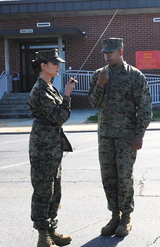 Then-Staff Sgt. Morgon Latimore, OSJA, instructs Cpl. JoAnna Sudduth on sword     manual in the rear parking lot of Building 3500, Jan. 27.