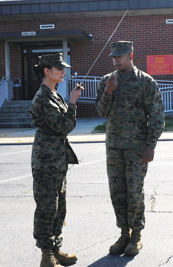 Then-Staff Sgt. Morgon Latimore, OSJA, instructs Cpl. JoAnna Sudduth on sword     manual in the rear parking lot of Building 3500, Jan. 27.