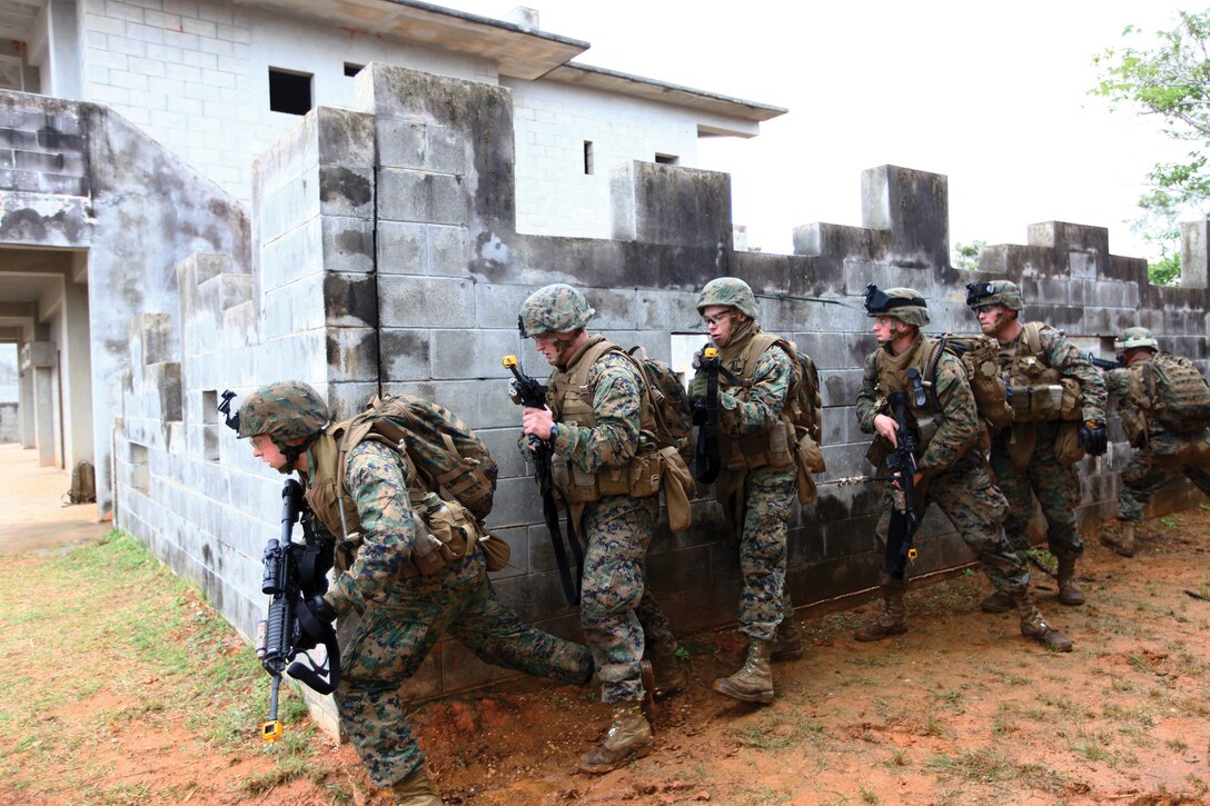 Amphibious Assault Vehicle Company Marines stack up and begin to move on a building inside Combat Town located in the Central Taining Area. Lessons learned the day prior allowed the Marines to move in an alert, rapid fashion between the buildings.