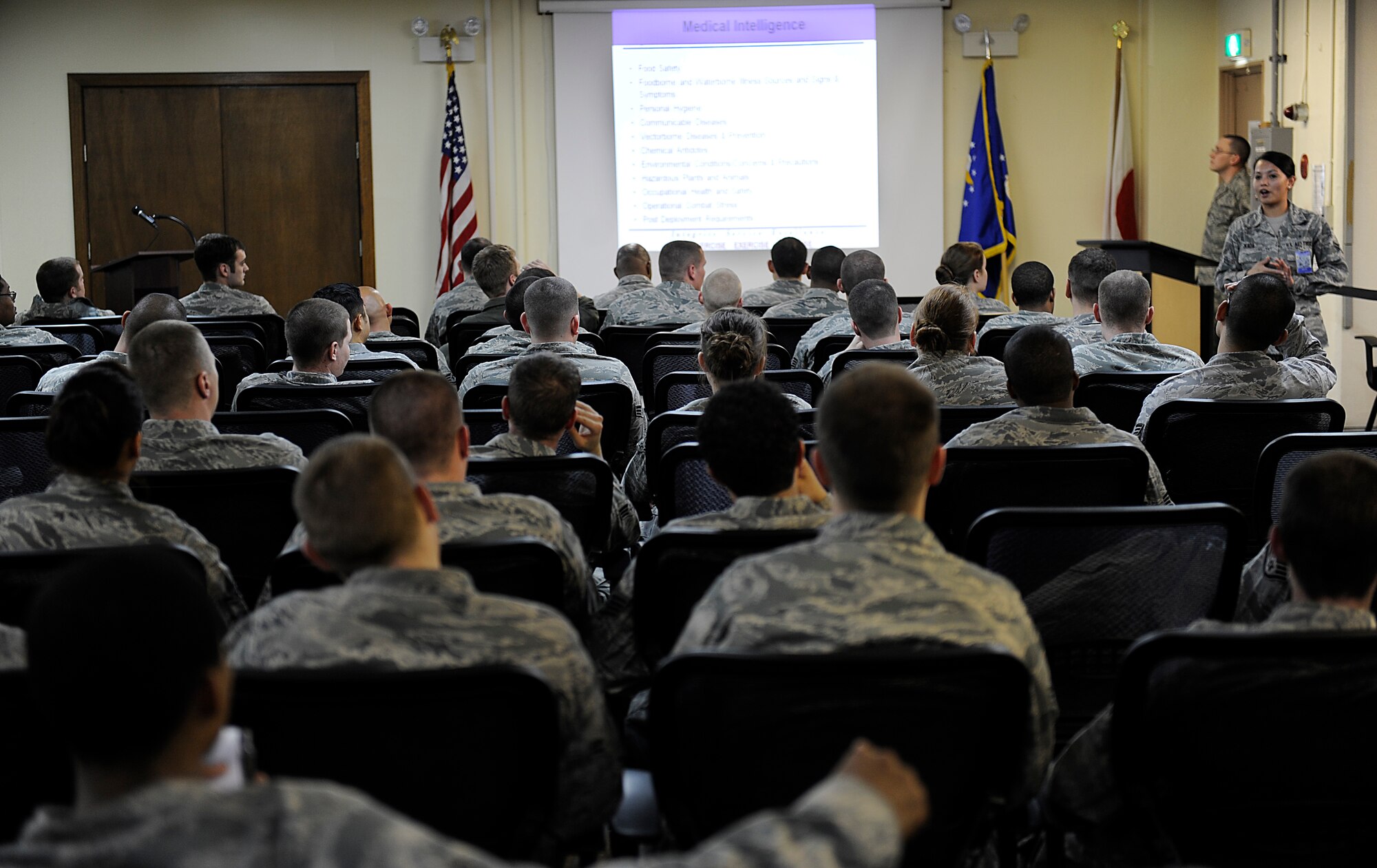 Simulated deployers listen to a Public Health brief by Airman 1st Class Katherine Okada, 18th Aerospace Medicine Squadron Public Health technician during Beverly High 12-2, a local operational readiness exercise on Kadena Air Base, Japan, Jan 10. Before deploying, Airmen receive briefings from chaplains, the Airman and Family Readiness Center, Public Health, the legal office and Public Affairs to ensure they are ready for day-to-day situations in a deployed environment. (U.S. Air Force photo by Airman 1st Class Maeson L. Elleman/Released)