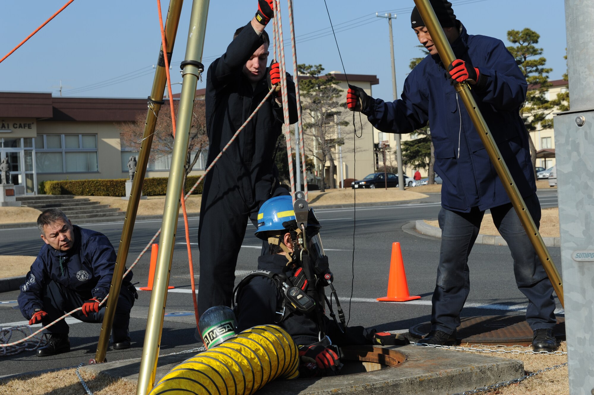 YOKOTA AIR BASE, Japan -- Kenji Ohkoshi, a firefighter with the 374th Civil Engineer Squadron, ascends from a manhole during a Confined Space Rescue Team demonstration. The demonstration gave wing leadership the opportunity to observe the team's capability to perform rescue operations in hazardous, confined environments. (U.S. Air Force photo/Capt. Raymond Geoffroy)