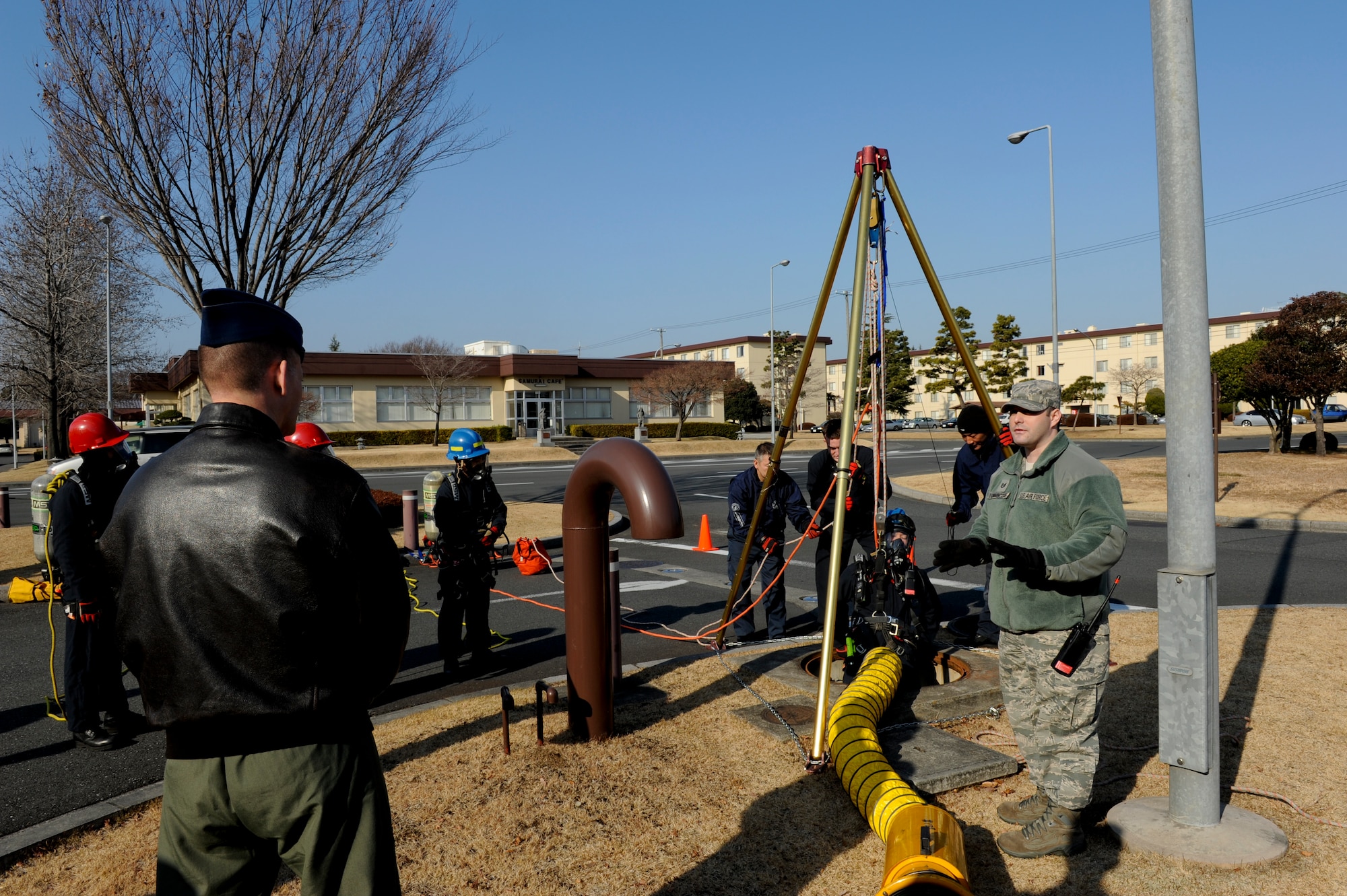 YOKOTA AIR BASE, Japan -- Col. Bill Knight, 374th Airlift Wing vice commander, and members of wing leadership observe as Kenji Ohkoshi, a firefighter with the 374th Civil Engineer Squadron, is lowered into a manhole during a Confined Space Rescue Team demonstration. The demonstration gave wing leadership the opportunity to observe the team's capability to perform rescue operations in hazardous, confined environments. (U.S. Air Force photo/Capt. Raymond Geoffroy)