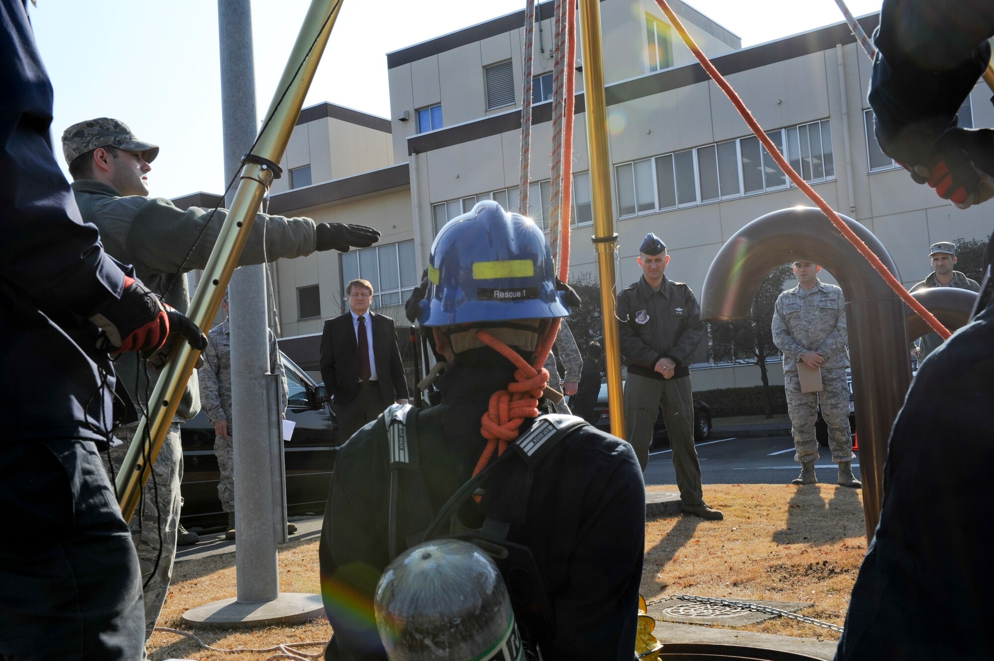 YOKOTA AIR BASE, Japan -- Col. Bill Knight, 374th Airlift Wing vice commander, and members of wing leadership observe as Kenji Ohkoshi, a firefighter with the 374th Civil Engineer Squadron, is lowered into a manhole during a Confined Space Rescue Team demonstration. The demonstration gave wing leadership the opportunity to observe the team's capability to perform rescue operations in hazardous, confined environments. (U.S. Air Force photo/Capt. Raymond Geoffroy)