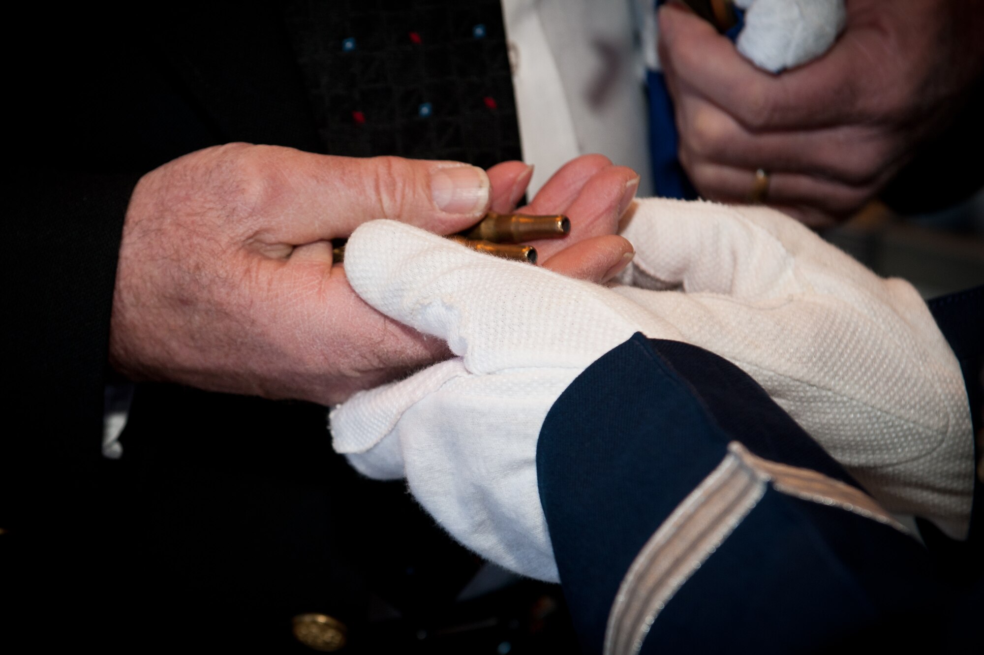 Tech. Sgt. Michael Lewis, Ellsworth Air Force Base Honor Guard NCO in charge, presents the shell casings from rounds fired during the rifle salute to the family members of a fallen military retiree during a funeral at the Black Hills National Cemetery near Sturgis, S.D., Jan. 6, 2012. Ceremonial Guardsmen retrieve the shells and place them in the hand of a loved one, signifying the loss to both the family and our country. (U.S. Air Force photo by Airman 1st Class Kate Thornton/Released) 