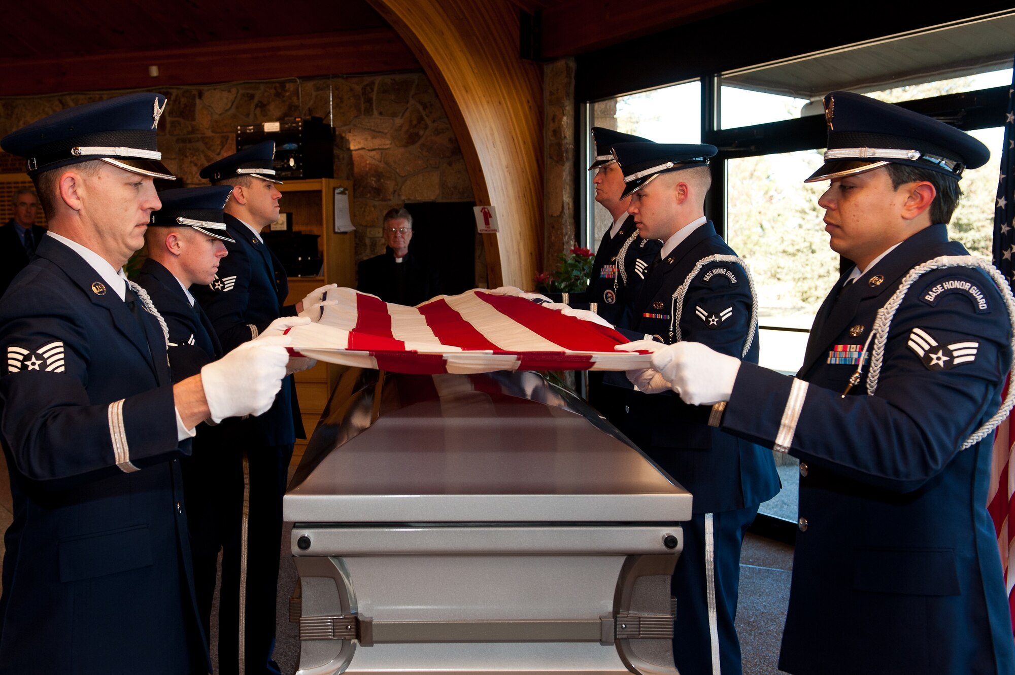 Airmen of the Ellsworth Air Force Base Honor Guard fold an American flag during a funeral at the Black Hills National Cemetery near Sturgis, S.D., Jan. 6, 2012. Once the flag is folded, the NCO in charge of presents the flag to the military member’s next of kin in honor of their loved one's faithful military service. (U.S. Air Force photo by Airman 1st Class Kate Thornton/Released)