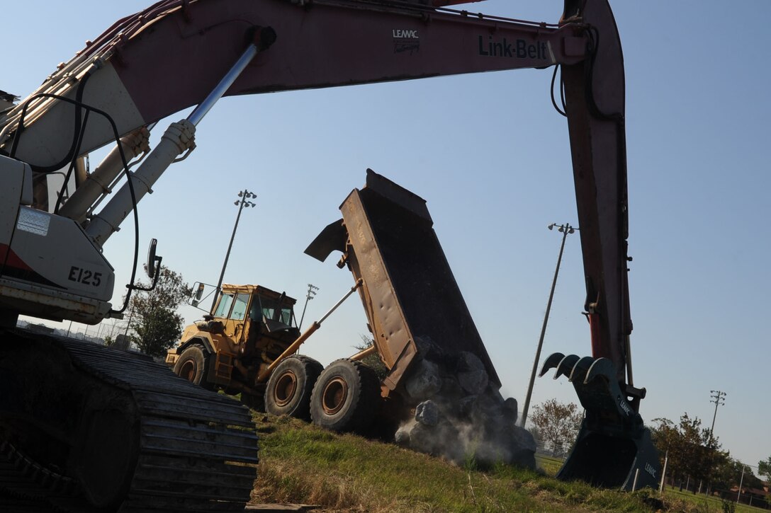 Construction workers unload granite rocks during the rebuilding of the shoreline along Ward Road at Langley Air Force Base, Va., Oct. 18, 2011. There are multiple construction projects happening on the installation that may impact traffic patterns, continue to read the Peninsula Warrior for updates. (U.S. Air Force photo by Airman 1st Class Racheal Watson/Released)