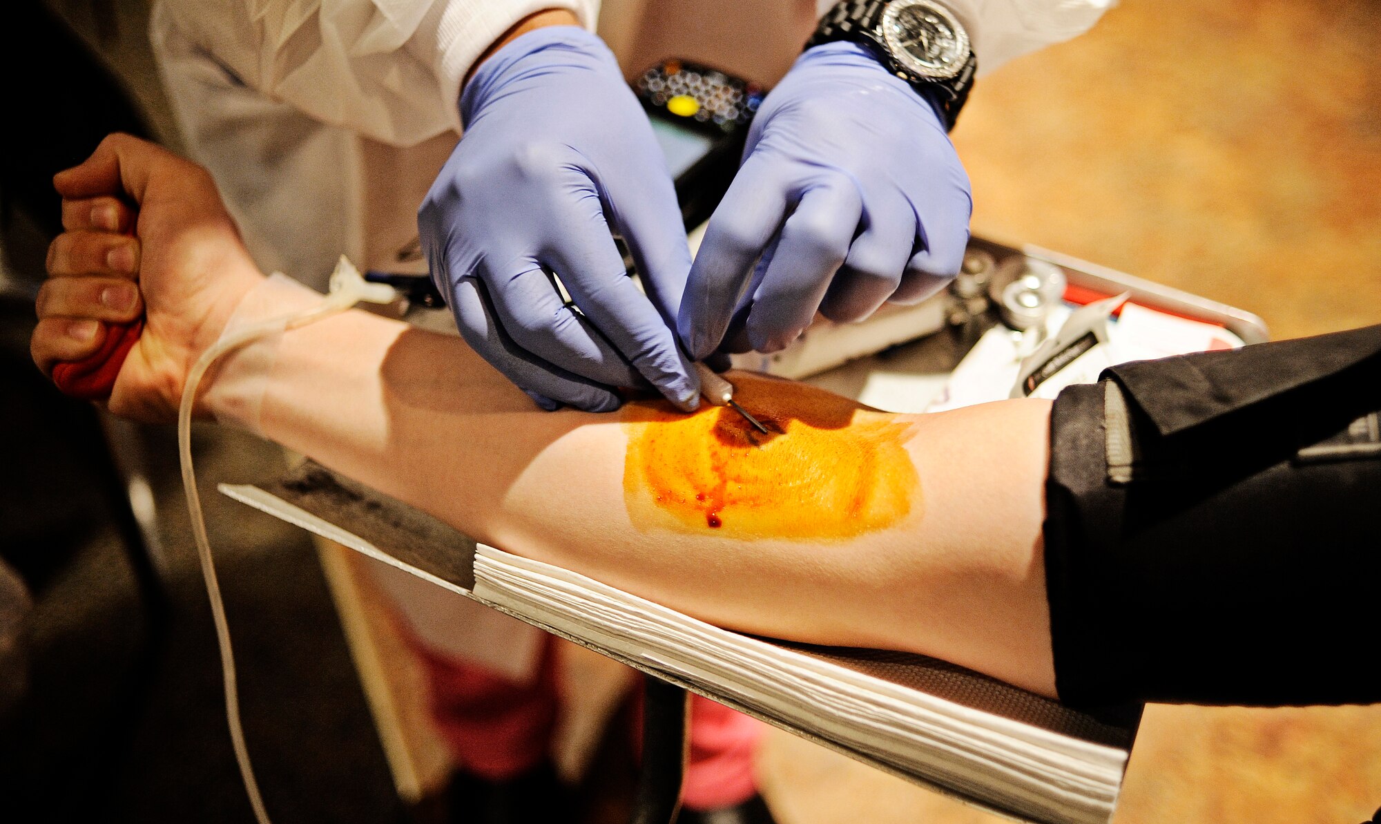 Senior Airman Justin Vaughan, Air Mobility Command intelligence analyst, squeezes a stress ball as the medical professional insert the needle into his vein during the first blood drive of the year Jan. 10, 2012. Last year Scott AFB donated more than 950 units of blood, but Col. Michael Hornitschek, 375th Air Mobility Wing commander, wants to beat that goal this year and has set a goal of 120 units for the opening blood drive. (U.S. Air Force photo/ Staff Sgt. Ryan Crane)