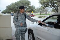 Airman 1st Class Julian Solis, 902nd Security Forces Squadron, checks IDs at the front gate on Joint Base San Antonio-Randolph Jan. 9.  The 902nd SFS has recently transitioned from 12- to eight-hour shifts. (U.S. Air Force photo/Rich McFadden) (released)