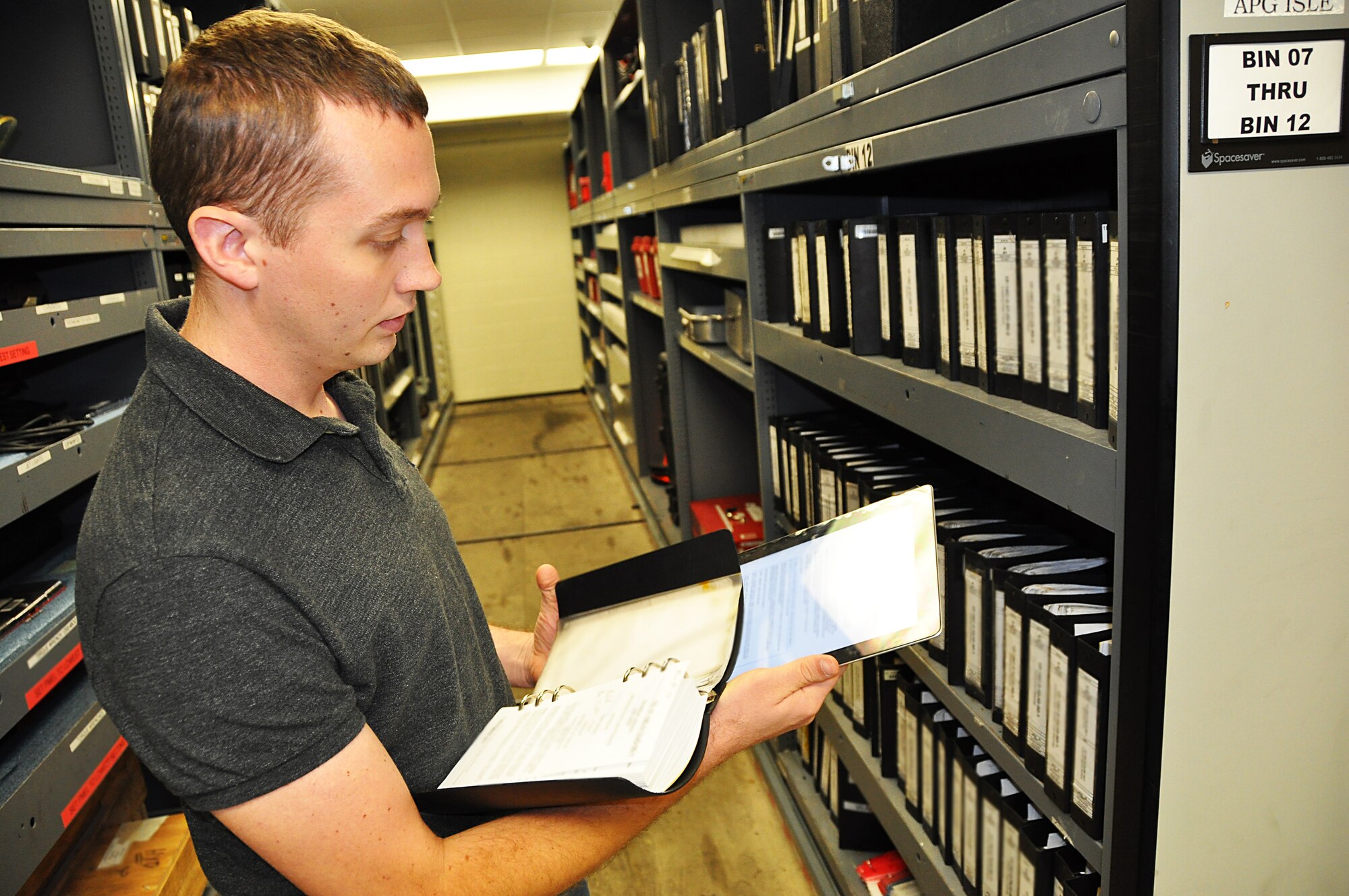 Mr. Corey Runge, Technical Order Distribution Office for Quality Assurance, 482nd Maintenance Group compares the new Apple iPad2 to the numerous volumes of technical orders. The Maintenance Group is participating in a 90-day technology upgrade test project in hopes to replace numerous books with the iPad2. (US Air Force photo/Staff Sgt. Lou Burton)