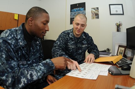 Petty Officer 3rd Class Ryan Davis (left) and Petty Officer 2nd Class Eric Martin review the Standard Form 87 fingerprint card and other important paperwork to ensure their accuracy prior to the forms being mailed to the Electronic Questionnaire for Investigation Processing department at  the Office of Personnel Management in Boyers, Pa. Martin is a Machinist’s Mate assigned to the 628th Security Forces Squadron Information Protection office at Joint Base Charleston – Weapons Station and Davis is a Ship’s Serviceman assigned to Naval Support Activity’s Unaccompanied Personnel Housing office at JB Charleston-Weapons Station. (U.S. Navy photo/Petty Officer 1st Class Jennifer Hudson)