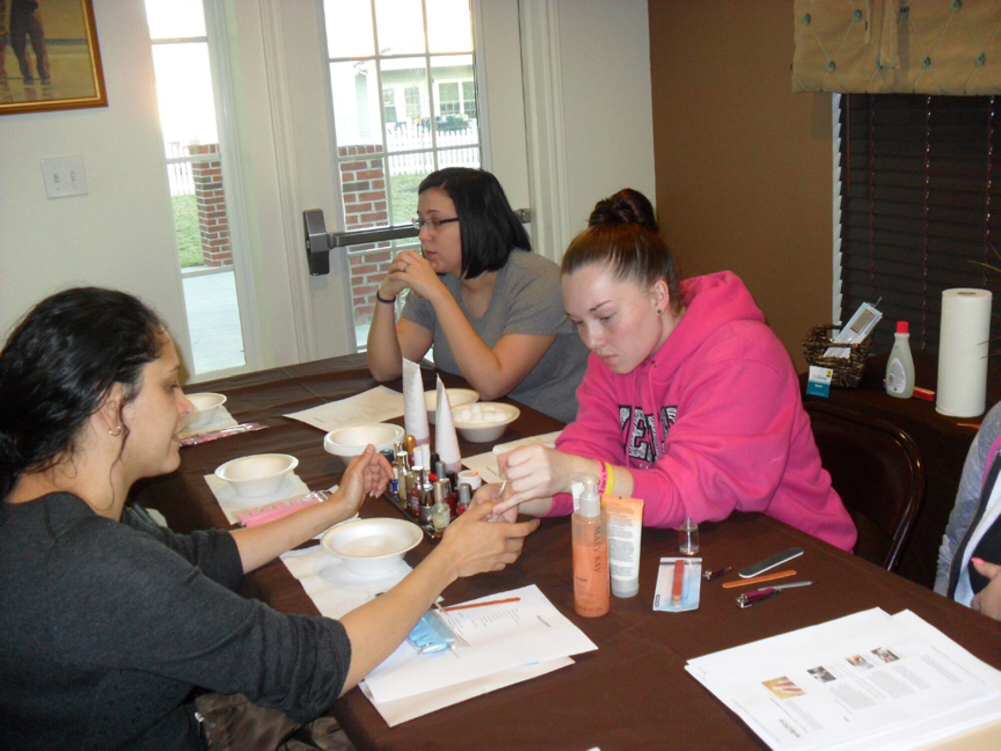 Students from Polytech High school (right) give manicures to spouses of deployed Airmen Jan. 6, 2012, during a Deployed Spouses Spa Night at Dover Air Force Base, Del. The Spa Night was to support those spouses whose partner was deployed for 30 days or more and those whose partner had or would be deployed 90 days before or after the event. More than 60 spouses attended the event which was supported by local business and school groups.  (U.S. Air Force courtesy photo)