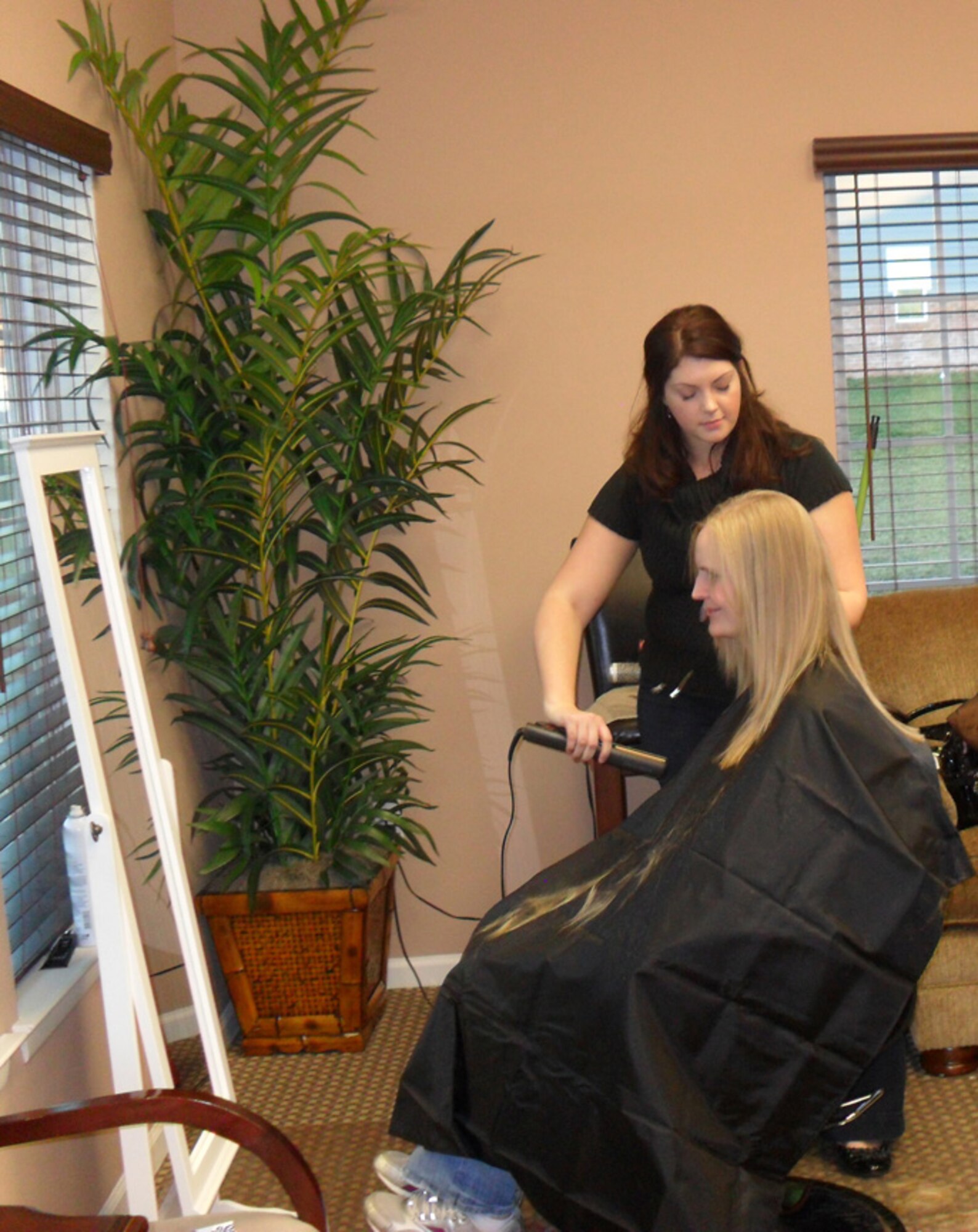 Dana Hess, hairstylist, styles the hair of a spouse of a deployed Airmen Jan. 6, 2012, during a Deployed Spouses Spa Night at Dover Air Force Base, Del. More than 60 spouses attended the event, which was partly funded by the Officer Spouse's Club. (U.S. Air Force courtesy photo)
