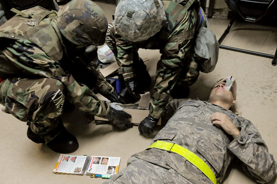 U.S. Air Force Airmen 1st Class Adam Linzy and Raymond Borja, 18th Logistics Readiness Squadron refueling unit operators, practice self-aid and buddy care (SABC) on a fellow Airman during local operational readiness exercise Beverly High 12-2, on Kadena Air Base, Japan, Jan. 10, 2012. Training on SABC is one area focused on during LOREs, along with mobility, deployment, reception, bedding down of forces and employment for possible real-world contingencies. (U.S. Air Force photo by Airman 1st Class Tara A. Williamson/Released)