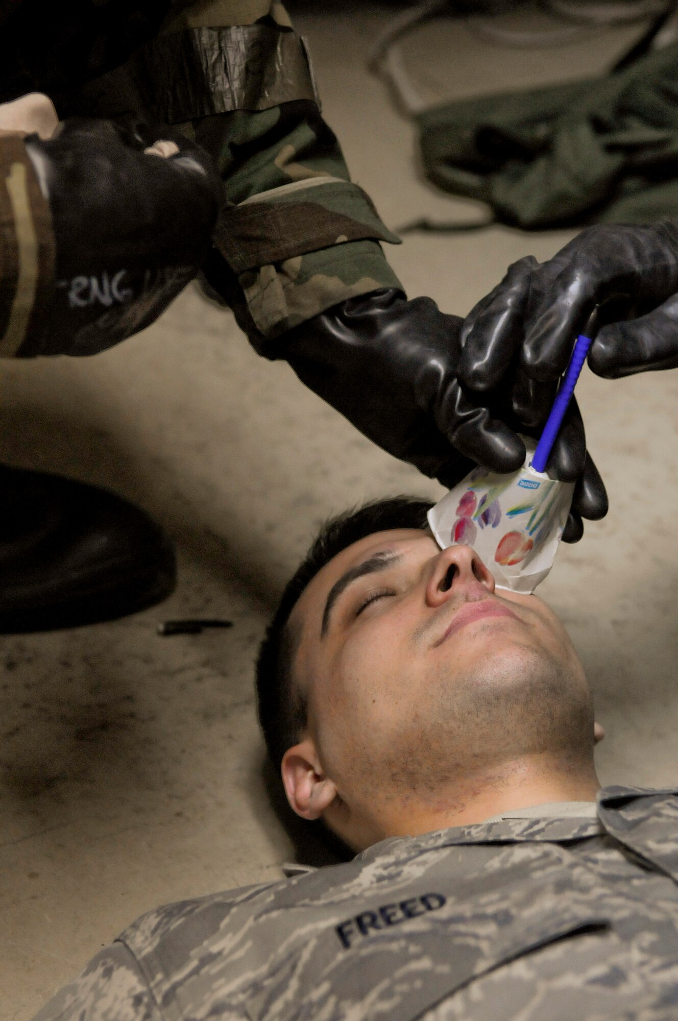 U.S. Air Force Airmen tend to a simulated victim while practicing self-aid and buddy care (SABC) during local operational readiness exercise Beverly High 12-2, on Kadena Air Base, Japan, Jan. 10, 2012. The SABC training gives Airmen the opportunity to practice providing care while wearing mission-oriented protective posture gear. (U.S. Air Force photo by Airman 1st Class Tara A. Williamson/Released)