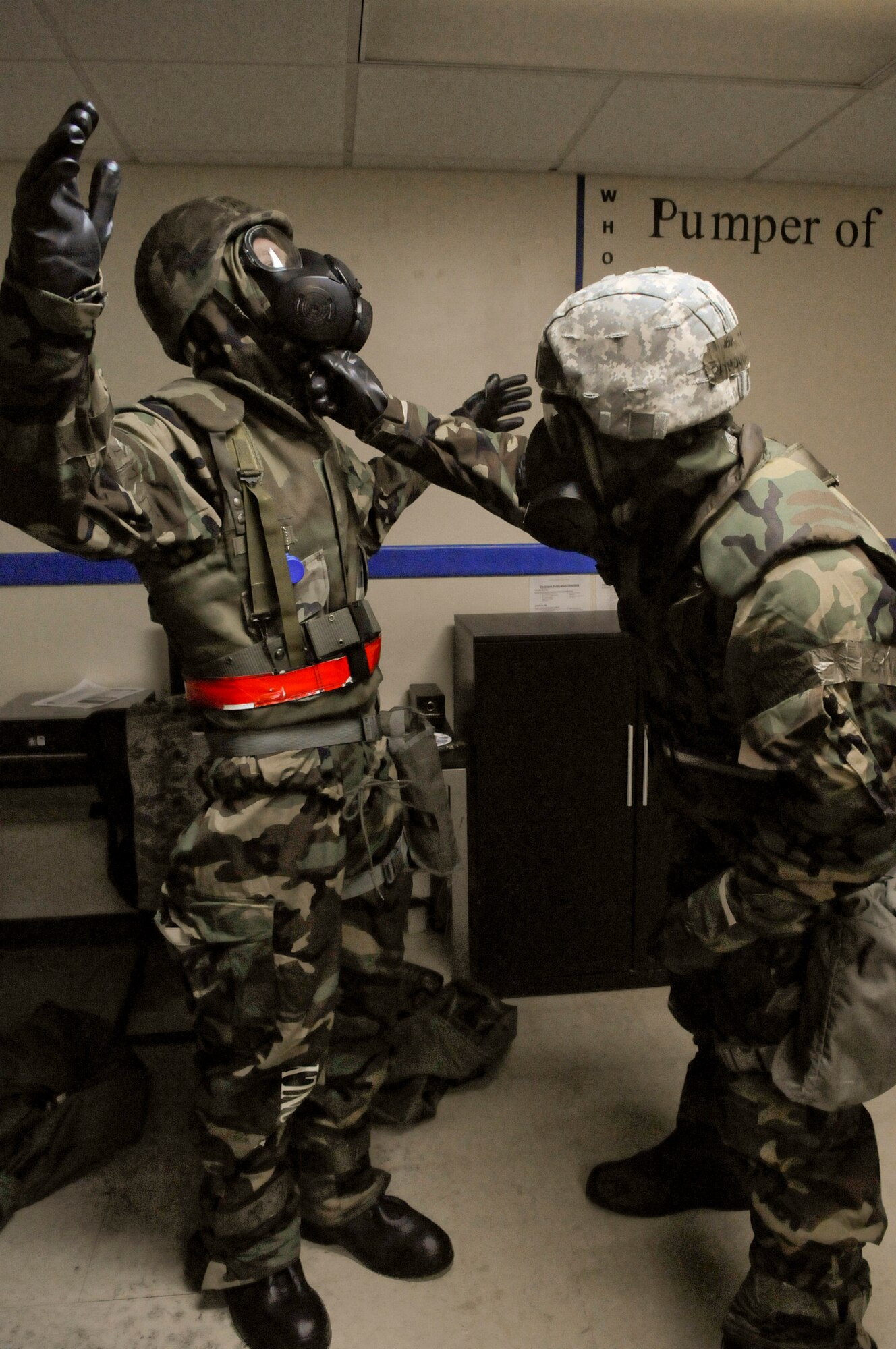 U.S. Air Force Airmen 1st Class Adam Linzy and Raymond Borja, 18th Logistics Readiness Squadron refueling unit operators, perform buddy checks to ensure their mission-oriented protective posture gear is worn correctly during local operational readiness exercise Beverly High 12-2, on Kadena Air Base, Japan, Jan. 10, 2012. Each LORE gives Kadena's Airmen the chance to train on mobility, deployment, reception, bedding down of forces, employment and self-aid and buddy care, for possible real-world contingencies. (U.S. Air Force photo by Airman 1st Class Tara A. Williamson/Released)