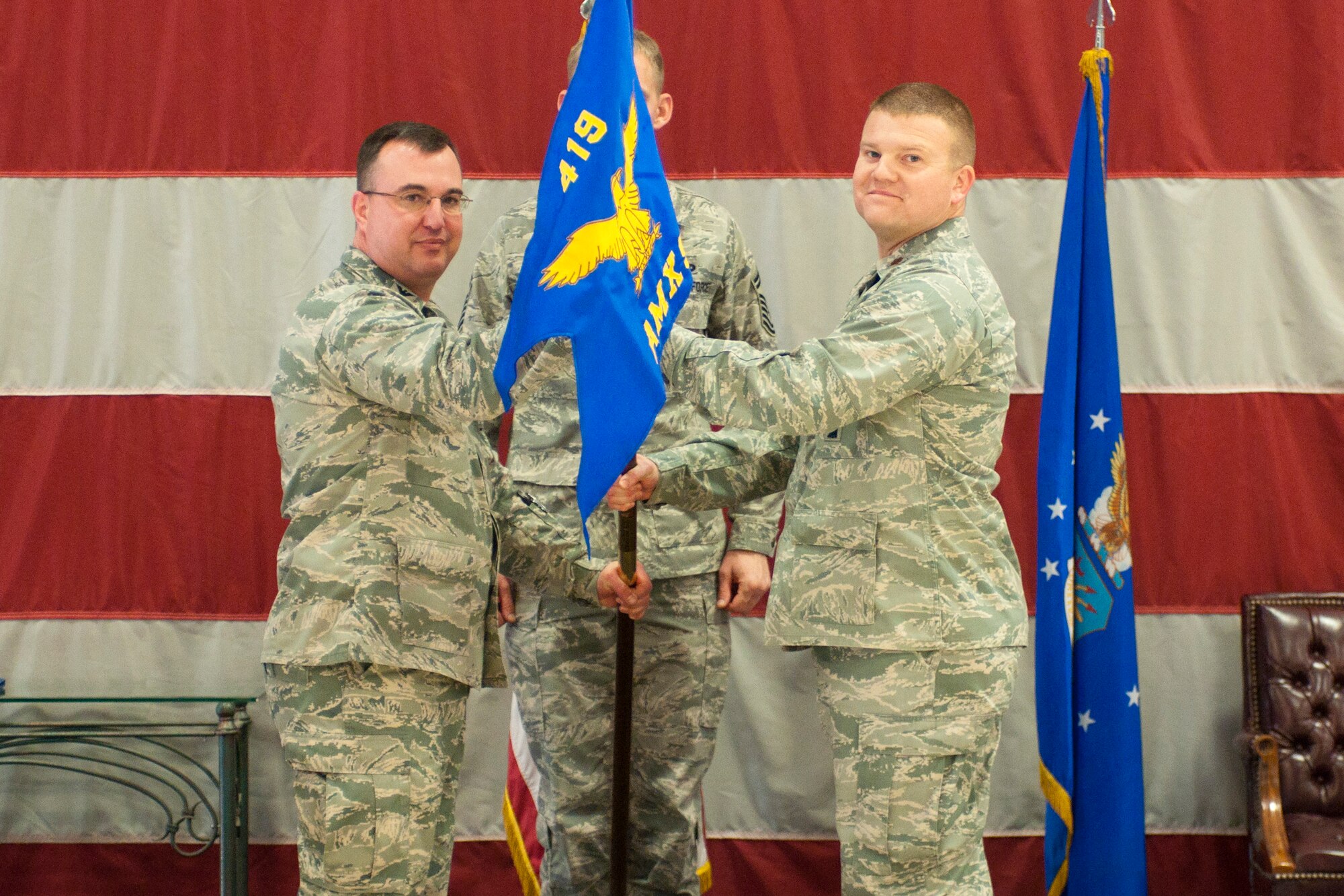 Col. Patrick Webb (left), 419th Maintenance Group commander, passes the squadron flag to Maj. Kyle Hosman, new Commander of the 419th Aircraft Maintenance Squadron, at a ceremony here Saturday. Hosman formerly served as 419th Maintenance Squadron commander. (U.S. Air Force photo/Staff Sgt. Kyle Brasier)