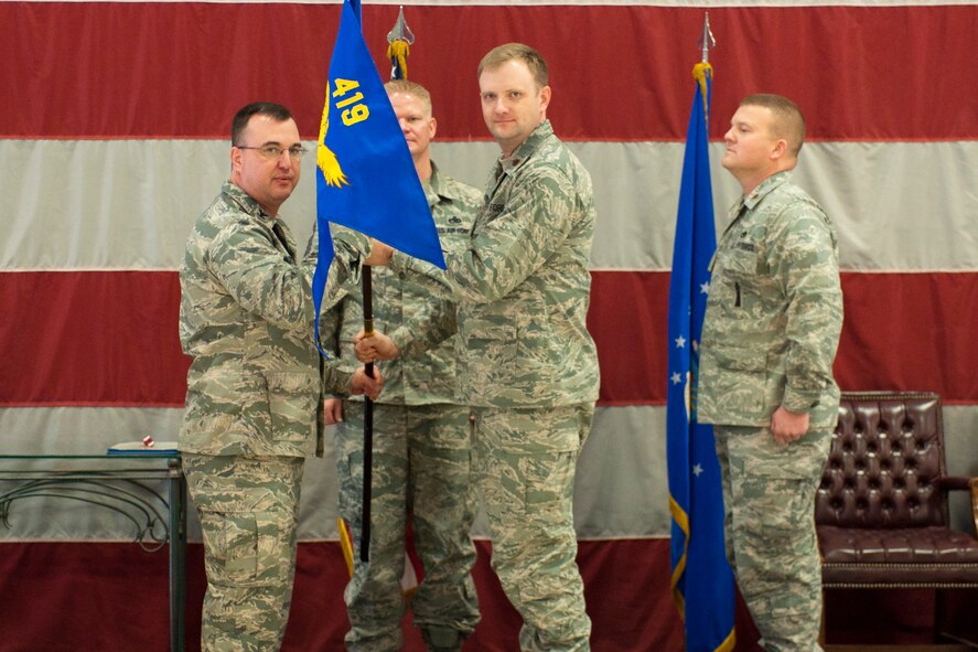 Maj. Ronald Carver, 419th Maintenance Squadron commander, accepts the squadron flag from Col. Patrick Webb, 419th Maintenance Group commander, at a change-of-command ceremony here Saturday. Carver previously served as the 419th MXS operations officer. (U.S. Air Force photo/Staff Sgt. Kyle Brasier)