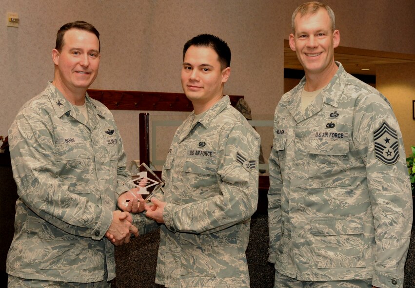 Col. Timothy Bush, 319th Air Base Wing commander, presents Senior Airman Jan Vincent Pilapil, 319th Force Support Squadron, with a Diamond Sharp Award Jan. 10 on Grand Forks Air Force Base, N.D., accompanied by 319th ABW Command Chief Master Sgt. David Carlson. The Diamond Sharp Award is given to Airmen who epitomize service before self and strive for excellence at work and off duty. (U.S. Air Force photo by Airman 1st Class Xavier Navarro)