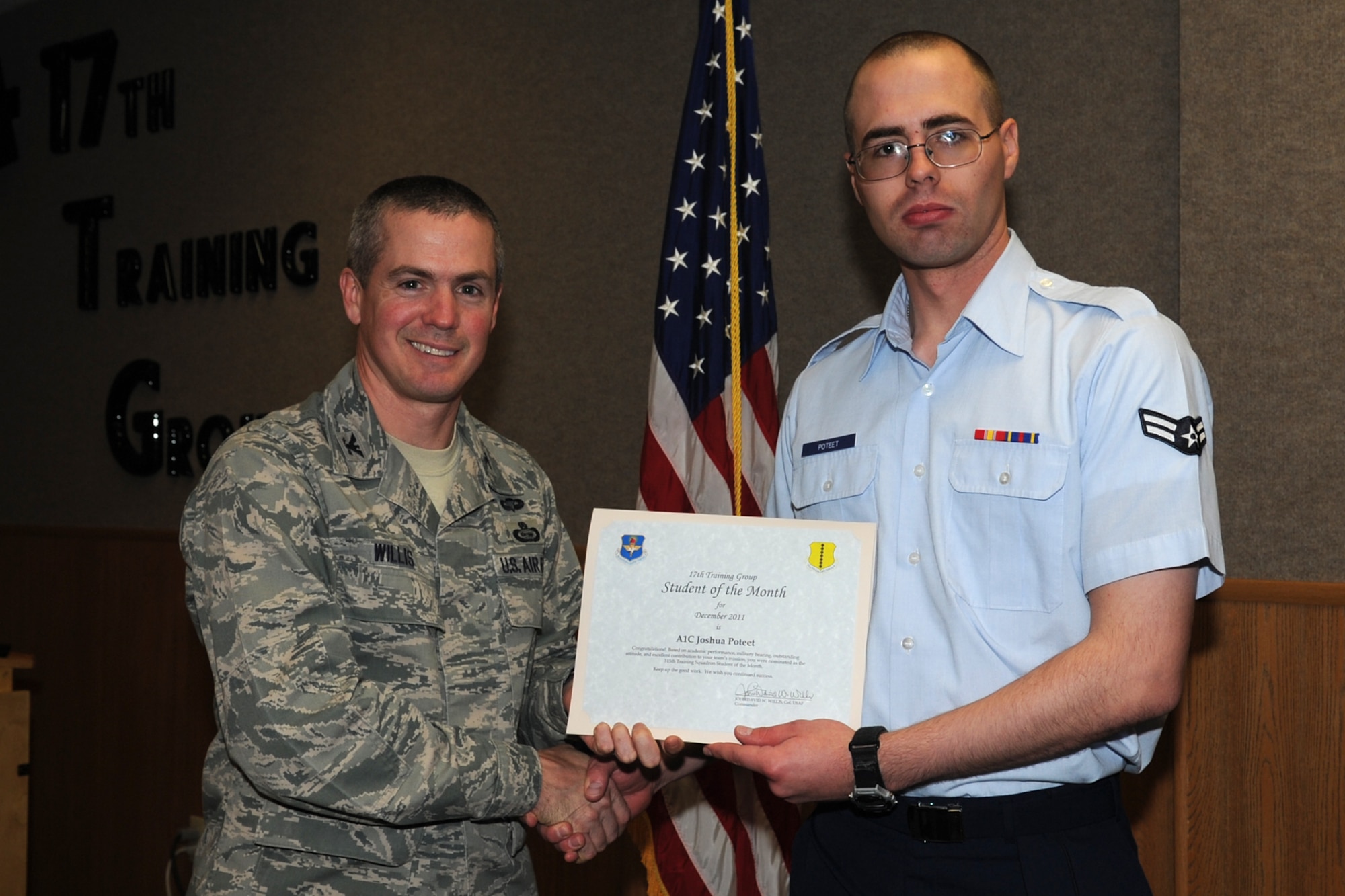 GOODFELLOW AIR FORCE BASE, Texas -- Col. JD Willis, 17th Training Group Commander, presents Airman 1st Class Joshua Poteet with the 315th Training Squadron Enlisted Student of the Month award for December, Jan. 6. (U.S. Air Force photo/Staff Sgt. Laura R. McFarlane)