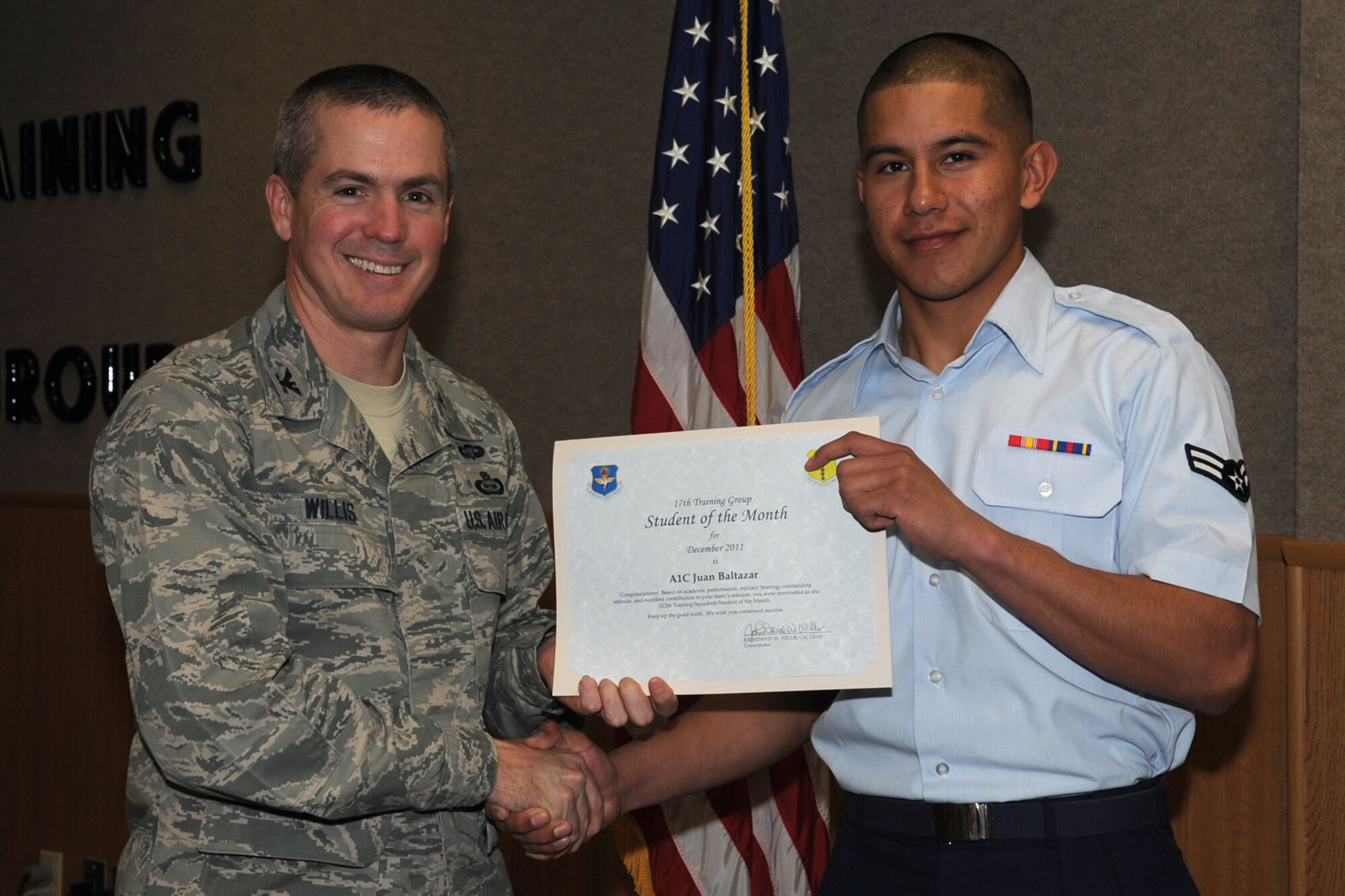 GOODFELLOW AIR FORCE BASE, Texas -- Col. JD Willis, 17th Training Group Commander, presents Airman 1st Class Juan Baltazar with the 312th Training Squadron Student of the Month award for December, Jan. 6. (U.S. Air Force photo/Staff Sgt. Laura R. McFarlane)