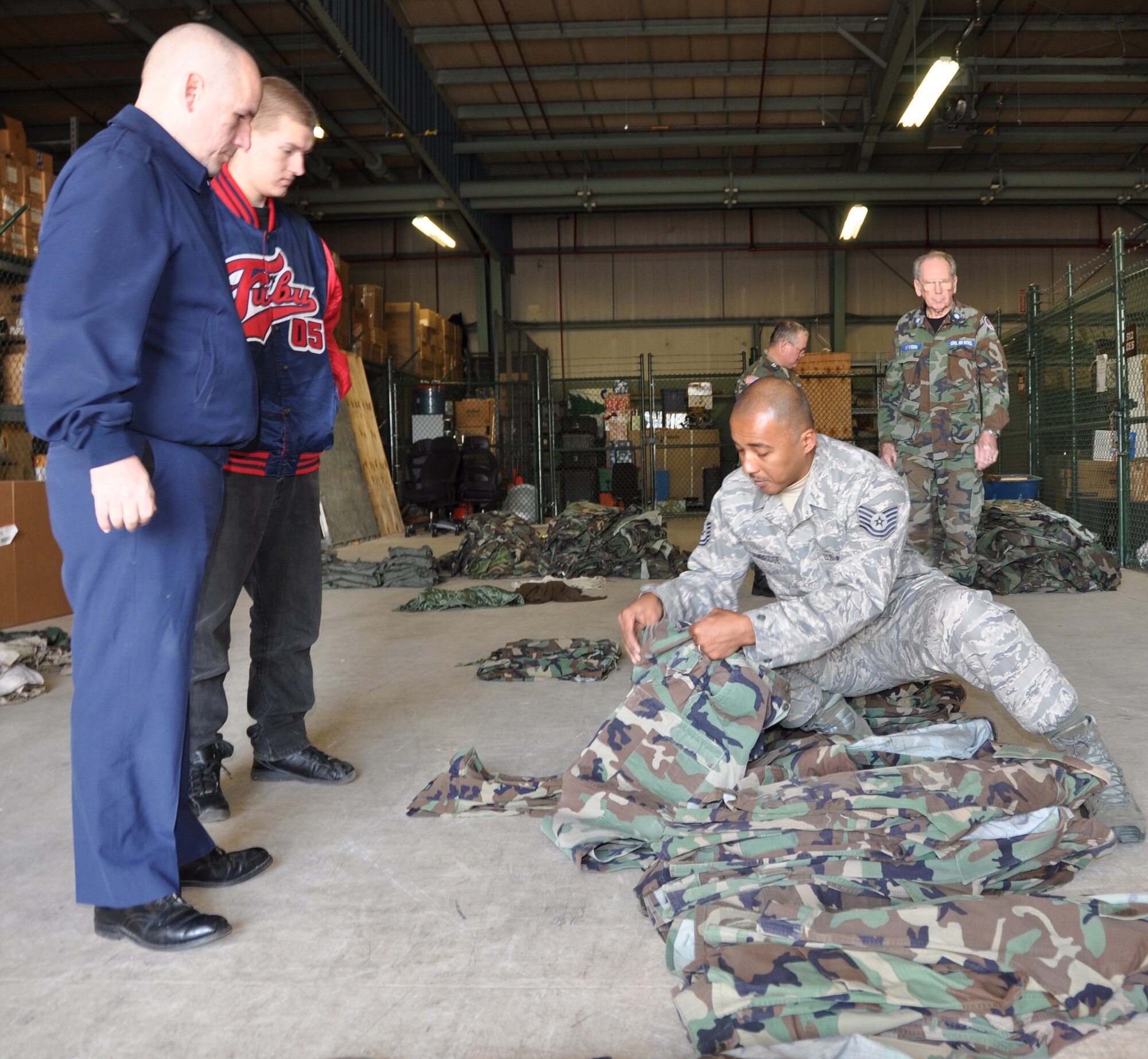 Tech. Sgt. Timmathy Cambridge (right), 512th Maintenance Operations Flight education and training manager, helps sort  donated battle dress uniforms in a hangar on Dover Air Force Base, Del., Jan. 8, 2012, when Civil Air Patrol members Capt. Ted Petroulis (left) and Master Sgt. Brandon came to pick-up the uniforms, collected through a wing drive for non-unit funded BDUs. The CAP is still authorized to wear BDUs after the BDU phase-out date of Nov. 1, 2011. About 125 sets of BDUs were donated to the Delaware Air National Guard Cadet Squadron, New Castle, Del, and the 904th Composite Squadron, Quakertown, Pa. (U.S. Air Force photo by Master Sgt. Veronica Aceveda)
