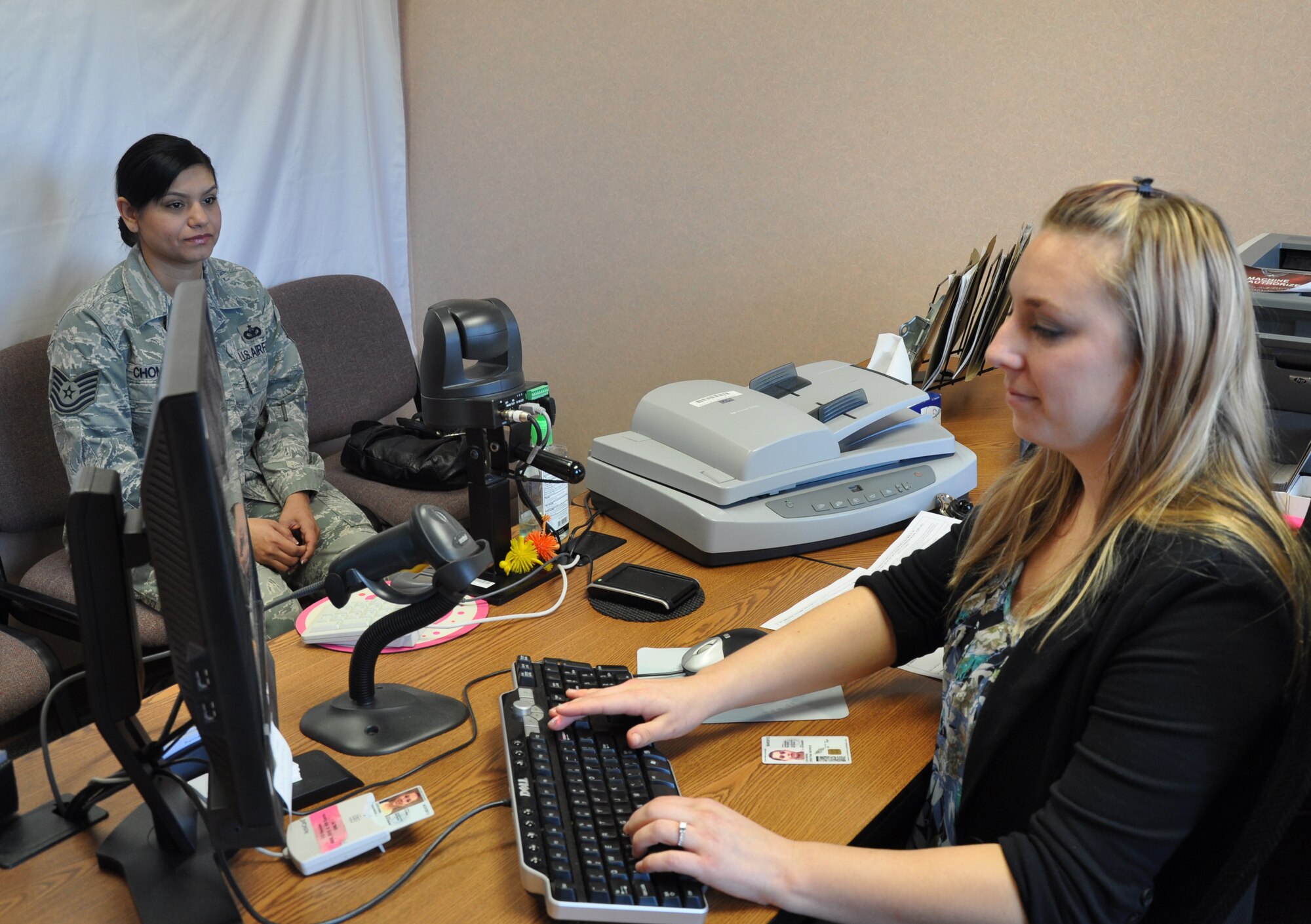 Shannon J. Geronimi, 9th Support Division Administrative Support Flight human resource assistant, helps Tech. Sgt. Cristina Chomina, 9th Security Forces Squadron,  update her common access card at Beale Air Force Base, Calif., Jan. 5, 2012. The ASF has improved customer service by reducing the number of steps it takes to produce an ID. (U.S. Air Force photo by Staff Sgt. Robert M. Trujillo)