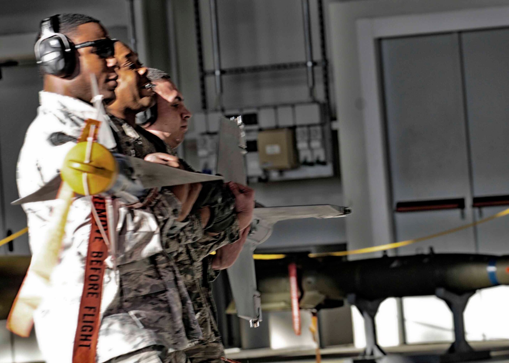 (From Foreground) Senior Airman Julius Thomas, 31st Maintenance Group weapons load crew member, Staff Sgt. Terelle Sayles weapons load crew chief and Senior Airman Carlos Del Valle, 31st Air Maintenance Squadron weapons load crew member carry a munition during a weapons loading competition Jan.6 at Aviano Air Base, Italy. Airmen from the 31st Maintenance Group and 510th Fighter Squadron competed against each other during the fourth quarter loading competition. (U.S. Air Force photo/Airman 1st Class Briana Jones)
