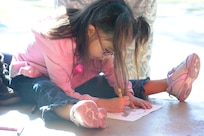 Kailea Miller colors her drawing to compete in the Picture Drawing Contest, at the 2d Annual Battle of the Badges, Jan 7, Randolph Air force Base, Texas. (U.S. Air Force photo/Joel Martinez)