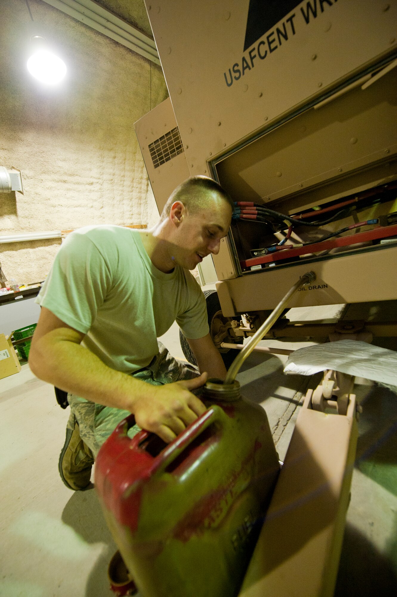 Airman 1st Class Dominic Januzzi, 332nd Expeditionary Civil Engineer Squadron power production flight, drains oil from a generator in an undisclosed location, Southwest Asia, Jan. 9, 2012. The power production flight inspected multiple generator sites and performed preventive maintenance inspections throughout their shop. Januzzi is deployed from Shaw Air Force Base, S.C. (U.S. Air Force photo by Staff Sgt. Joshua J. Garcia/Released)