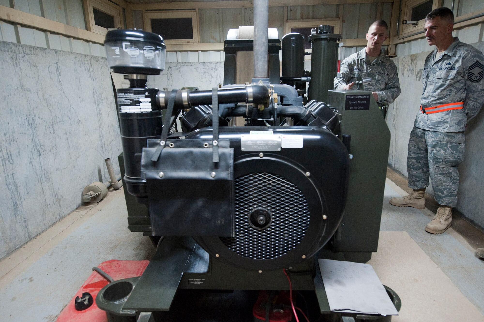 Staff Sgt. James Maxwell, 332nd Expeditionary Civil Engineer squadron power production flight, briefs Chief Master Sgt. John Brinkley, 332nd Air Expeditionary Wing command chief, on the Barrier Arresting Kit 12 at an undisclosed location in Southwest Asia, Jan. 9, 2012. The power production flight inspects the BAK12 system daily to ensure it is ready for use at a moment’s notice. Brinkley spent the evening working alongside the power production flight performing inspections and changing oil on generators. Maxwell is deployed from Shaw Air Force Base, S.C., and Brinkley is deployed from Scott Air Force Base, Ill.(U.S. Air Force photo by Staff Sgt. Joshua J. Garcia/Released