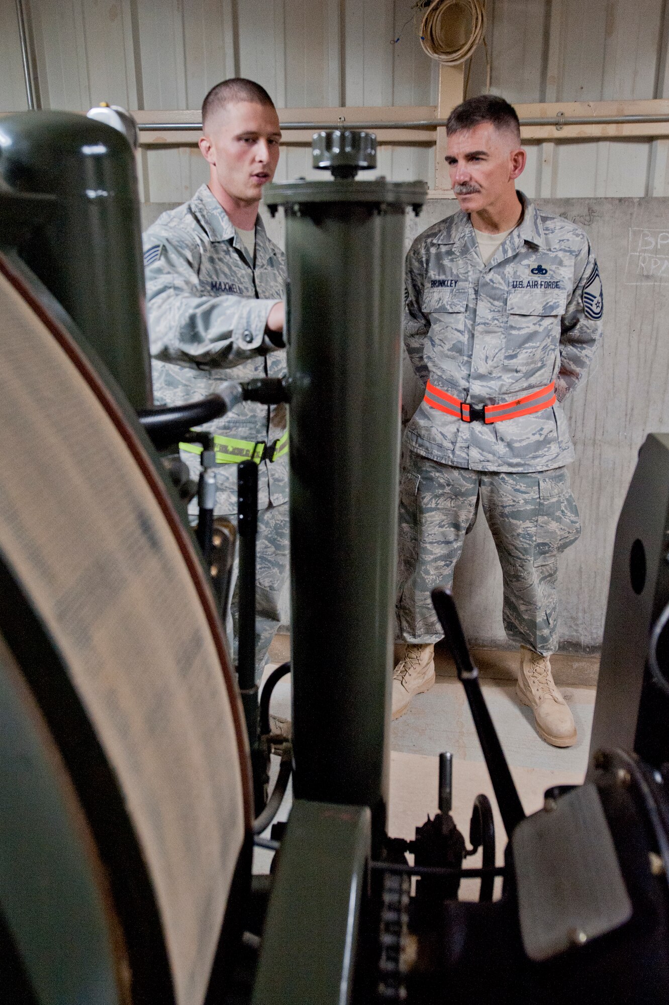 Staff Sgt. James Maxwell, 332nd Expeditionary Civil Engineer squadron power production flight, briefs Chief Master Sgt. John Brinkley, 332nd Air Expeditionary Wing command chief, on the Barrier Arresting Kit 12 at an undisclosed location in Southwest Asia, Jan. 9, 2012. The BAK12 is used is to catch aircraft equipped with a tow hook during an emergency landing. The power production flight inspects the BAK12 system daily to ensure it is ready for use at a moment’s notice. Maxwell is deployed from Shaw Air Force Base, S.C., and Brinkley is deployed from Scott Air Force Base, Ill. (U.S. Air Force photo by Staff Sgt. Joshua J. Garcia/Released)  