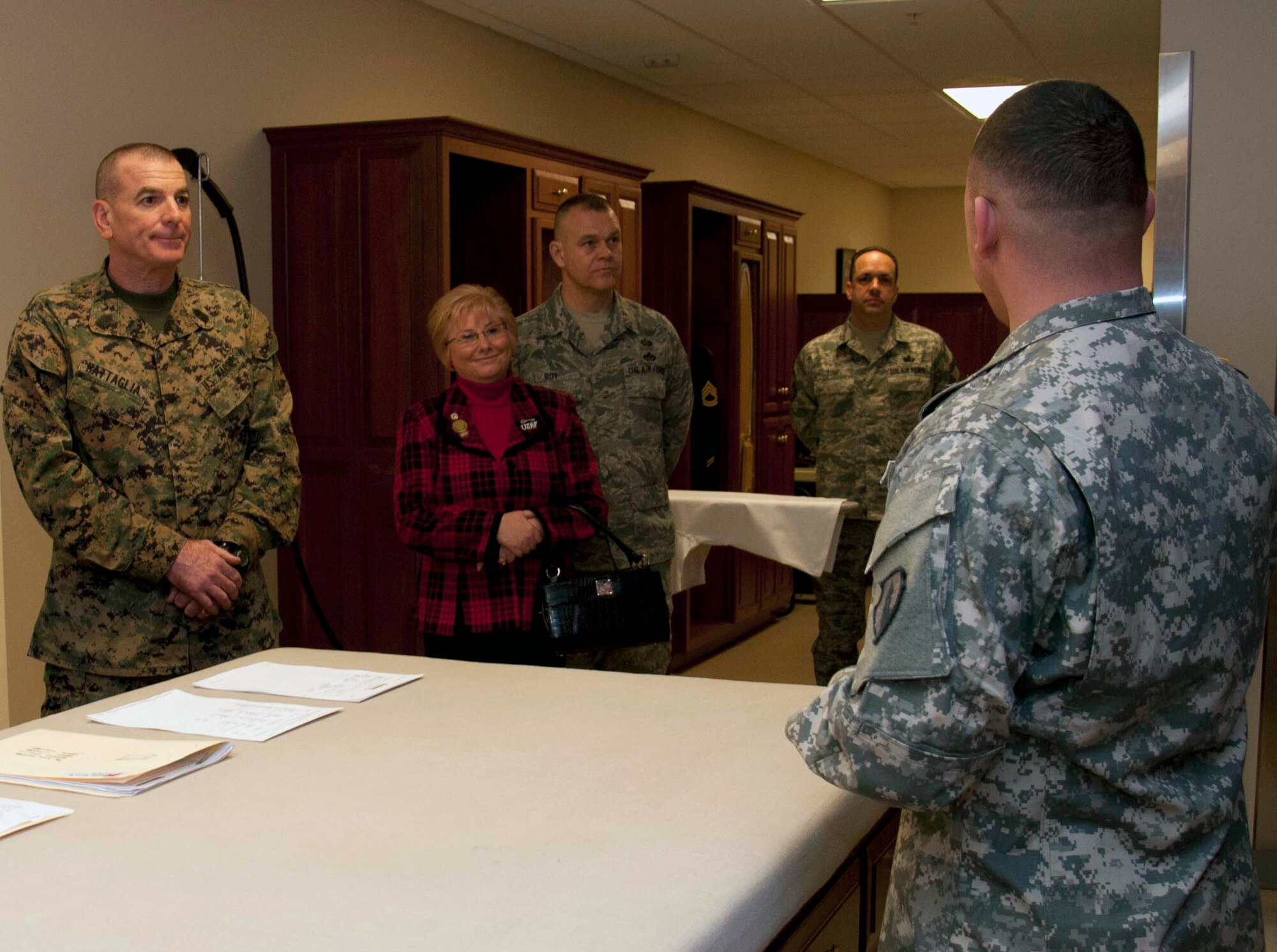 Marine Sgt. Maj. Bryan Battaglia, senior enlisted advisor to the Chairman of the Joint Chiefs of Staff, Paula Roy and her husband Chief Master Sgt. of the Air Force James Roy, listen as Army Sgt. Carlos Irizarry briefs them on the uniform shop at the Charles C. Carson Center for Mortuary Affairs Jan. 6, 2012. (U.S. Air Force photo/Staff Sgt. Agustin Salazar) 