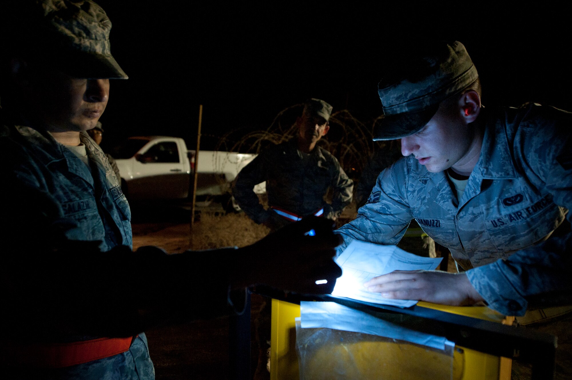 Chief Master Sgt. John Brinkley, 332nd Air Expeditionary Wing command chief, middle, watches as Staff Sgt. Mark Salazar and Airman 1st Class Dominic Januzzi, both from the 332nd Expeditionary Civil Engineer Squadron power production flight; sign off on an inspection sheet for a generator in an undisclosed location in Southwest Asia, Jan. 9, 2012. Brinkley accompanied the power production flight as they inspected multiple generator sites. Brinkley is deployed from Scott Air Force Base, Ill. Salazaar is deployed from Lajes Field, Azores, and Januzzi is deployed from Shaw Air Force Base, S.C. (U.S. Air Force photo by Staff Sgt. Joshua J. Garcia/Released)