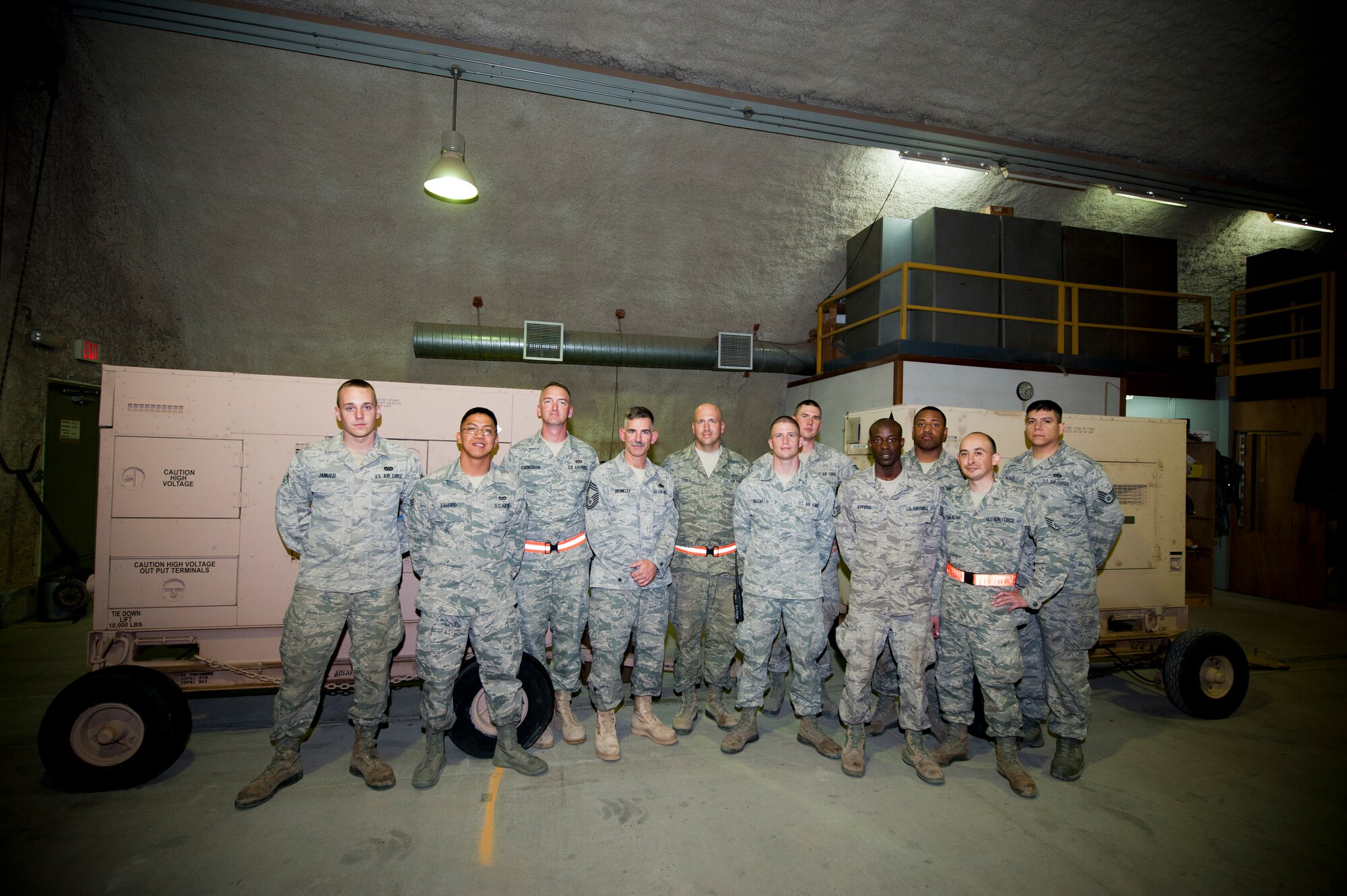 Chief Master Sgt. John Brinkley, 332nd Air Expeditionary Wing command chief, fourth from left, takes a group photo with the power production flight from the 332nd Expeditionary Civil Engineer Squadron, prior to going out with the flight to perform inspections on generators, in an undisclosed location in Southwest Asia, Jan. 9, 2012. Brinkley started a new program where he visits a flight and performs mission tasks alongside Airmen. (U.S. Air Force photo by Staff Sgt. Joshua J. Garcia/Released)