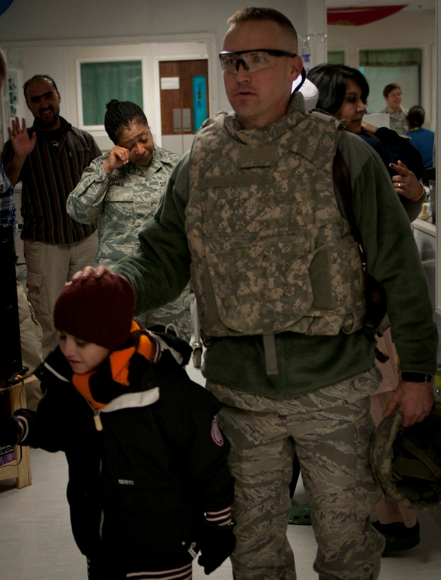 Maj. Sherrol James cries in the background as Maj. (Dr.) Joe DuBose escorts Najibullah out of the Craig Joint-Theater Hospital on Jan. 9, 2012, after being in its care for more than six months. Najibullah was severely injured in the stomach July 20, 2011, in Ghazni province and had been under the care of the hospital since. James is a chaplain at the Craig Joint-Theater Hospital, and DuBose is the trauma chief at the Craig Joint-Theater Hospital. (U.S. Army photo/Spc. Ken Scar)