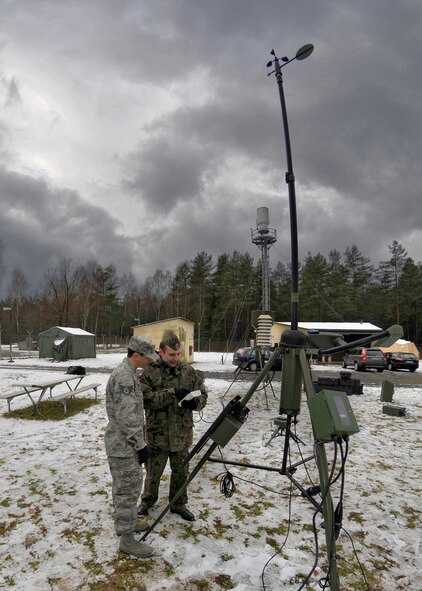 Storm clouds gather as Polish Air Force Capt. Sebastian Bernatowicz, a weather forecaster in the Polish Military Hydro-meteorological Service, makes a test reading from the deployable TMQ-53,a highly sensitive atmospheric measuring device at the Joint Multinational Training Command's Grafenwoehr Training Area in Grafenwoehr, Germany, Dec 6, 2011 during the Cadre Focus winter exercise. JMTC regularly hosts and facilitates multinational training exercises in support of U.S. and NATO forces. (U.S. Army photo by Michael Beaton)