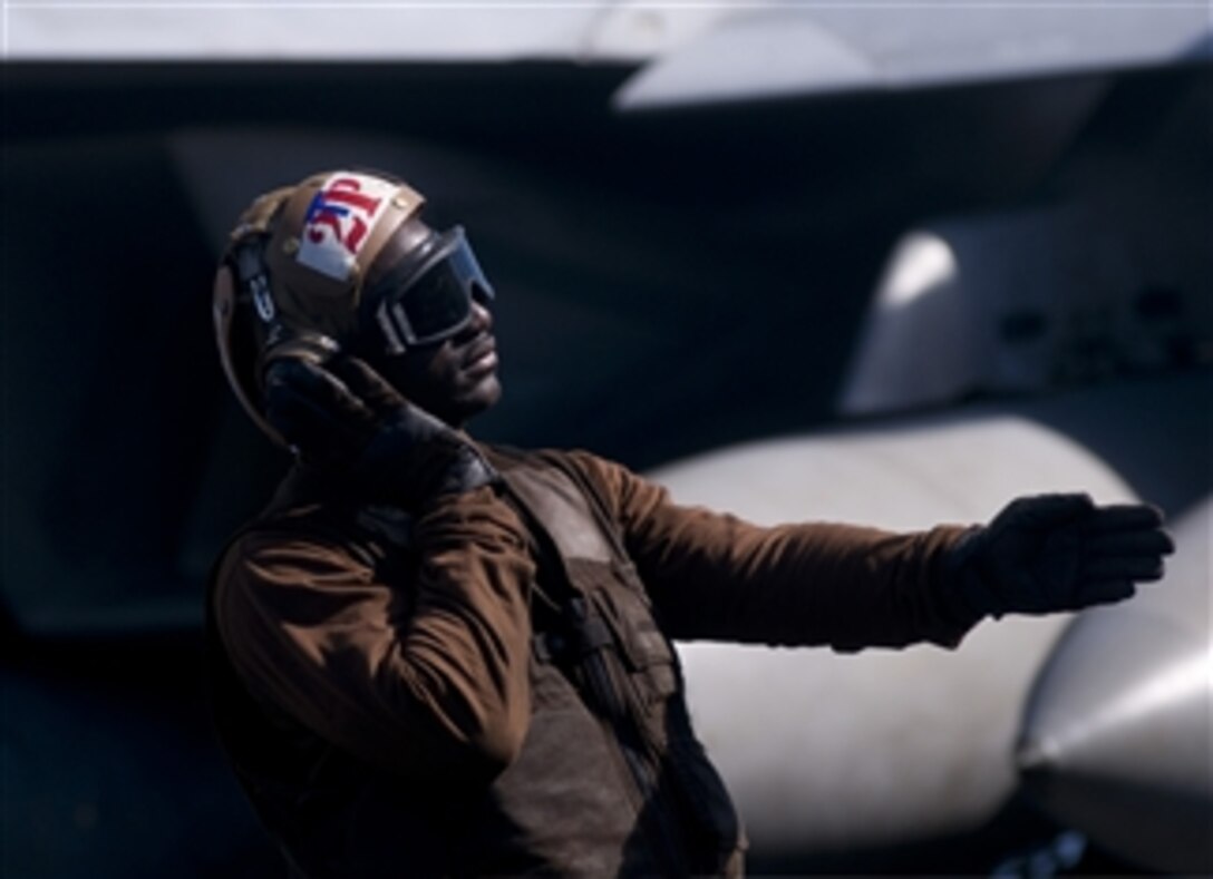 U.S. Navy Airman Michael Johnson, a plane captain assigned to Strike Fighter Squadron 81, signals to an F/A-18E Super Hornet aircraft pilot during startup procedures on the flight deck of the aircraft carrier USS Carl Vinson (CVN 70) in the Indian Ocean on Jan. 7, 2012.  The Carl Vinson and Carrier Air Wing 17 are under way on a western Pacific deployment.  